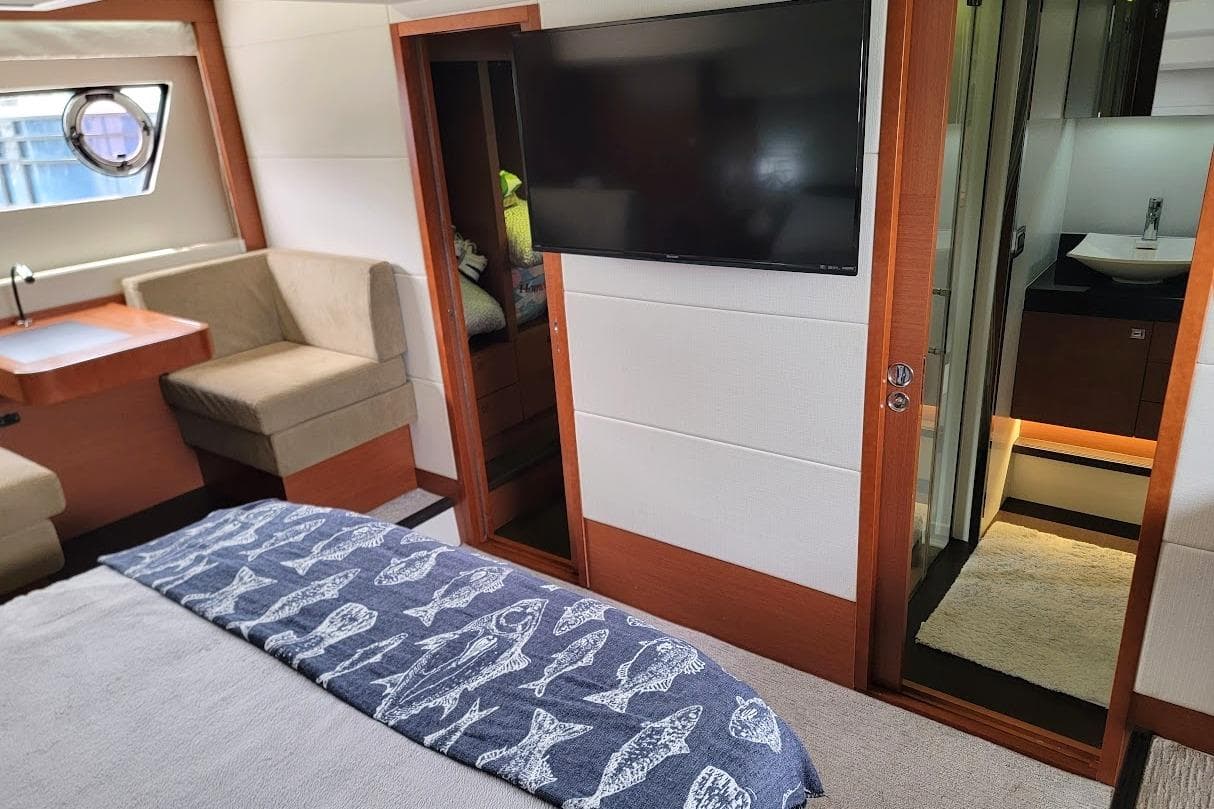 Luxurious interior of a 2014 Prestige 550 yacht with modern furnishings and a flat-screen TV.