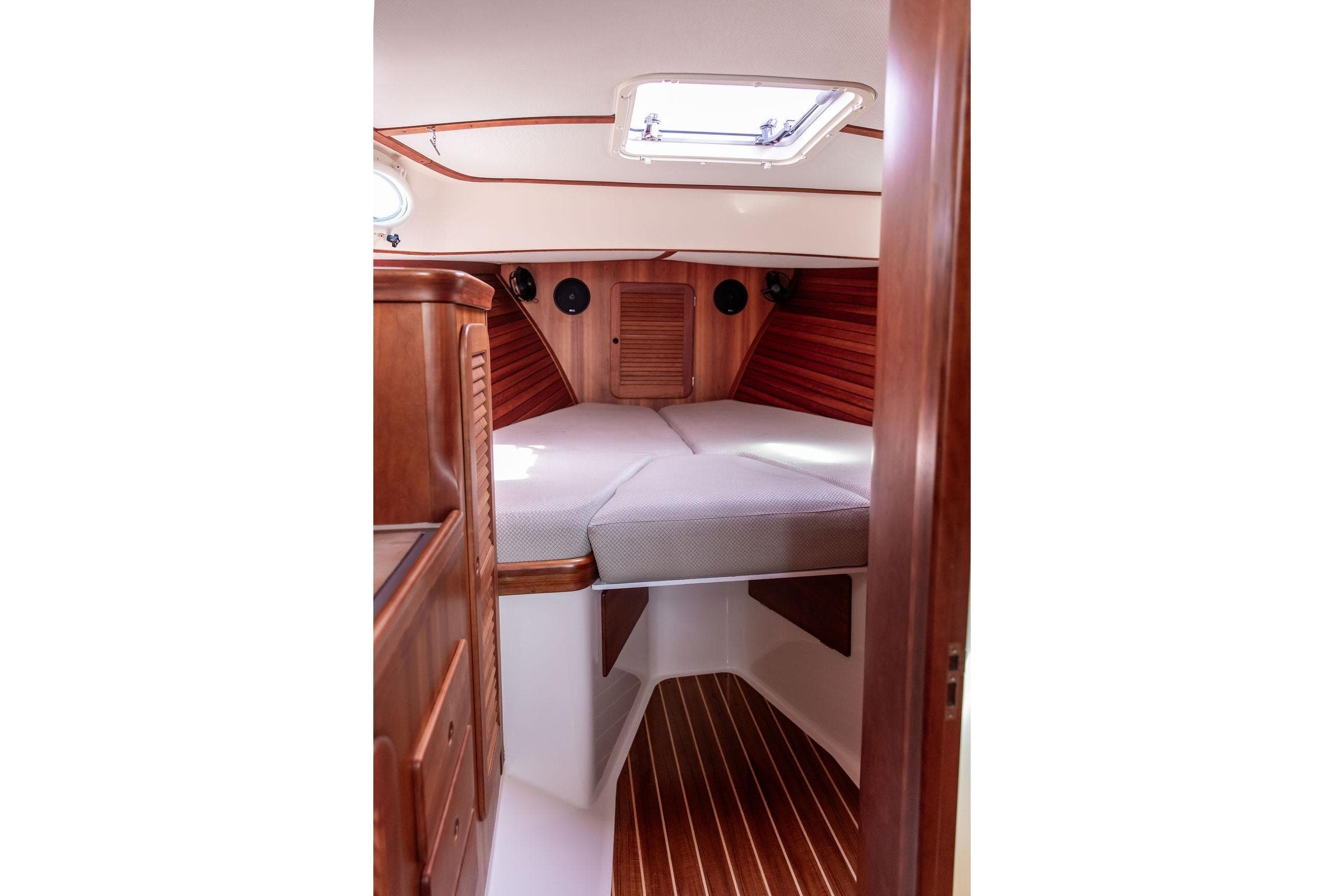2005 Hinckley Picnic Boat EP cabin interior with wooden finish and cozy bedding.