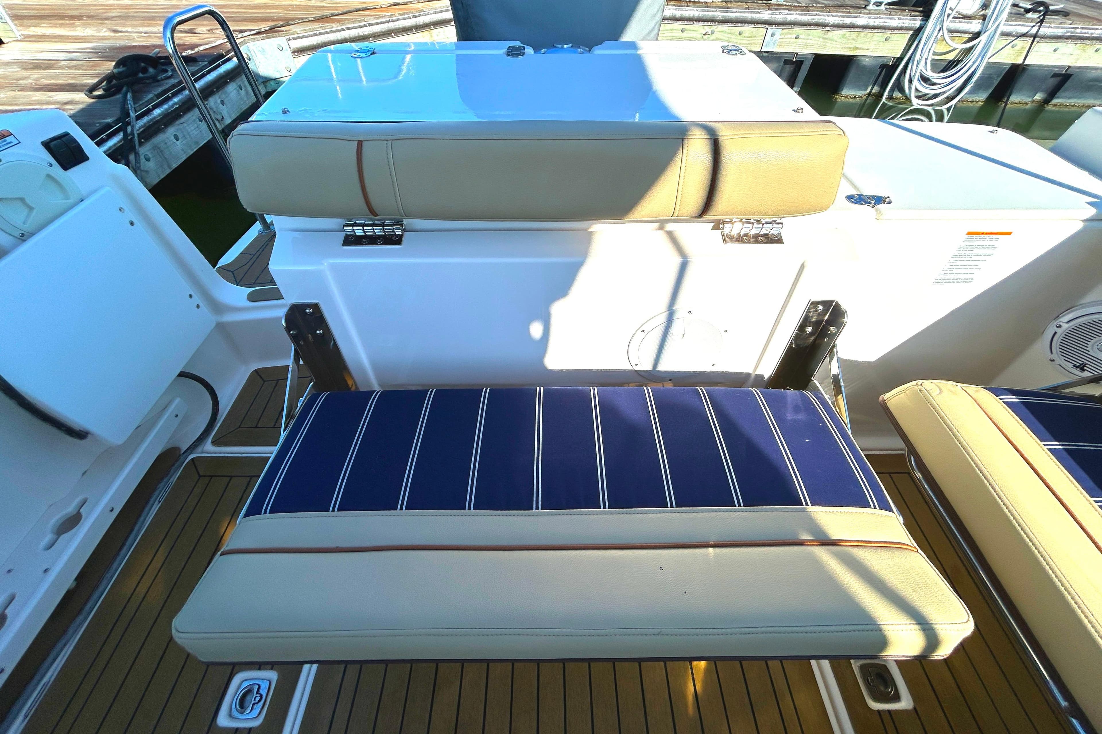 2020 Ranger Tugs R-27 boat seating with blue striped cushions and teak flooring.