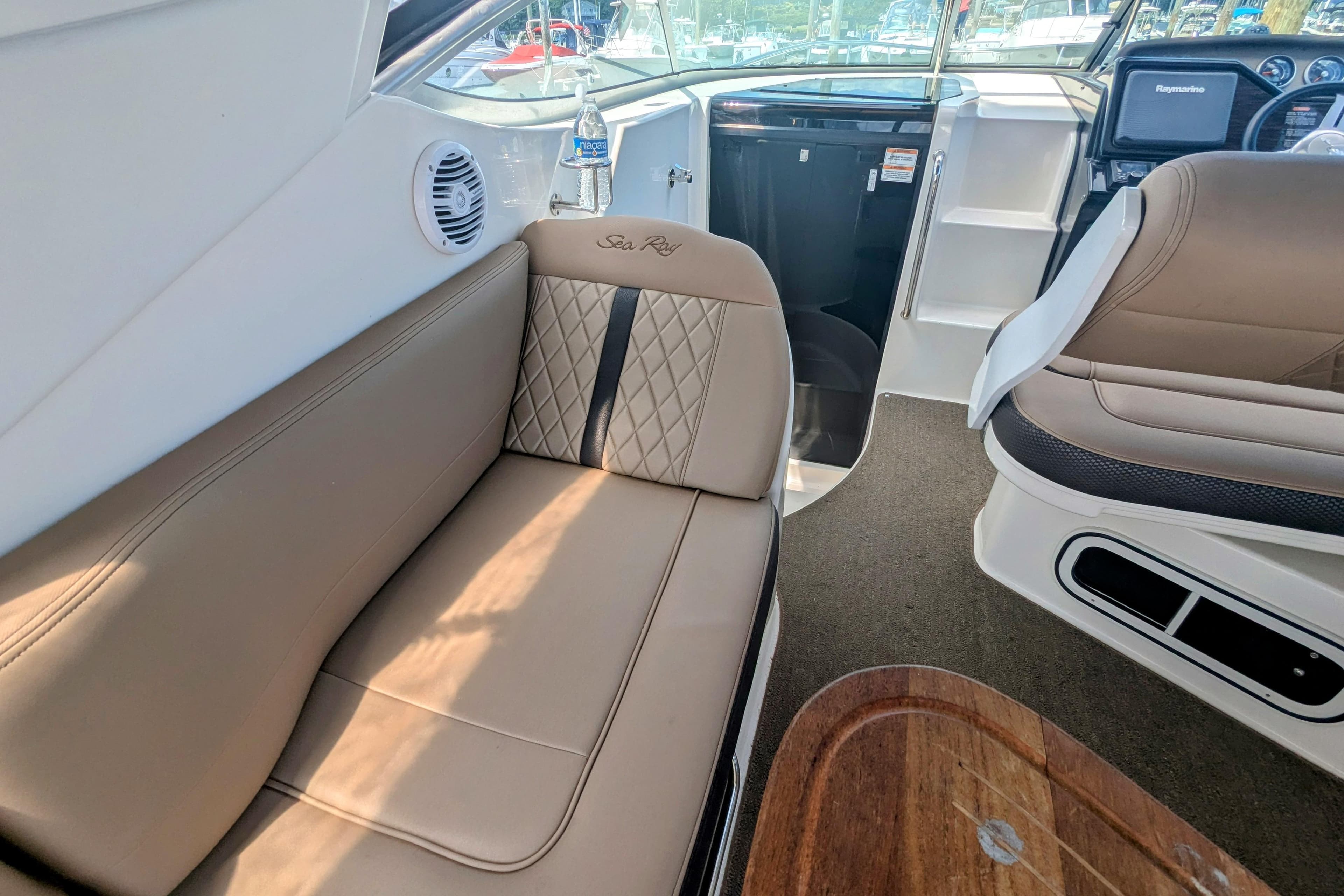 Interior of 2017 Sea Ray Sundancer 280, featuring beige seating and modern dashboard.