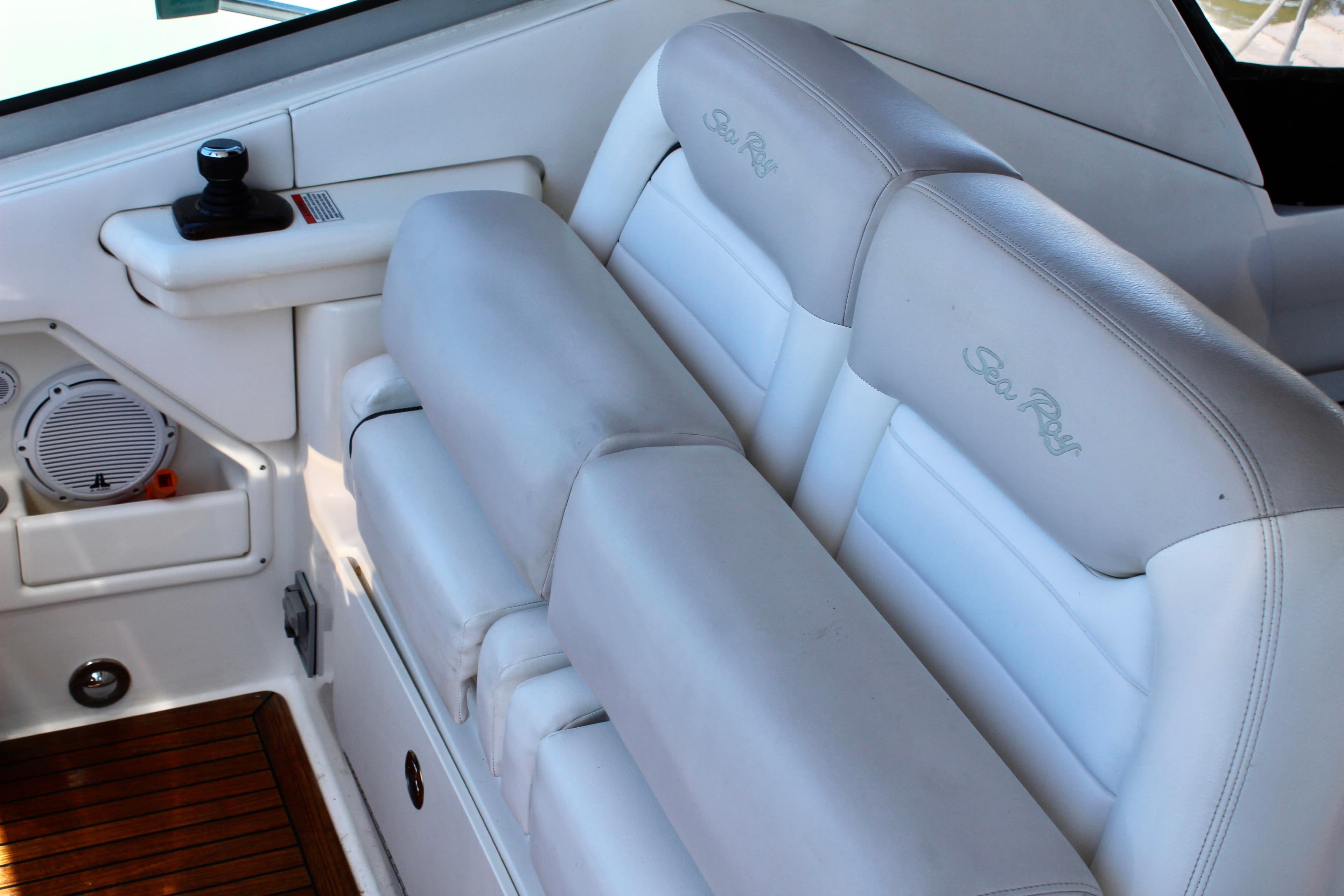 Interior seating of 2011 Sea Ray Sundancer 350 yacht with white upholstery and wood flooring.