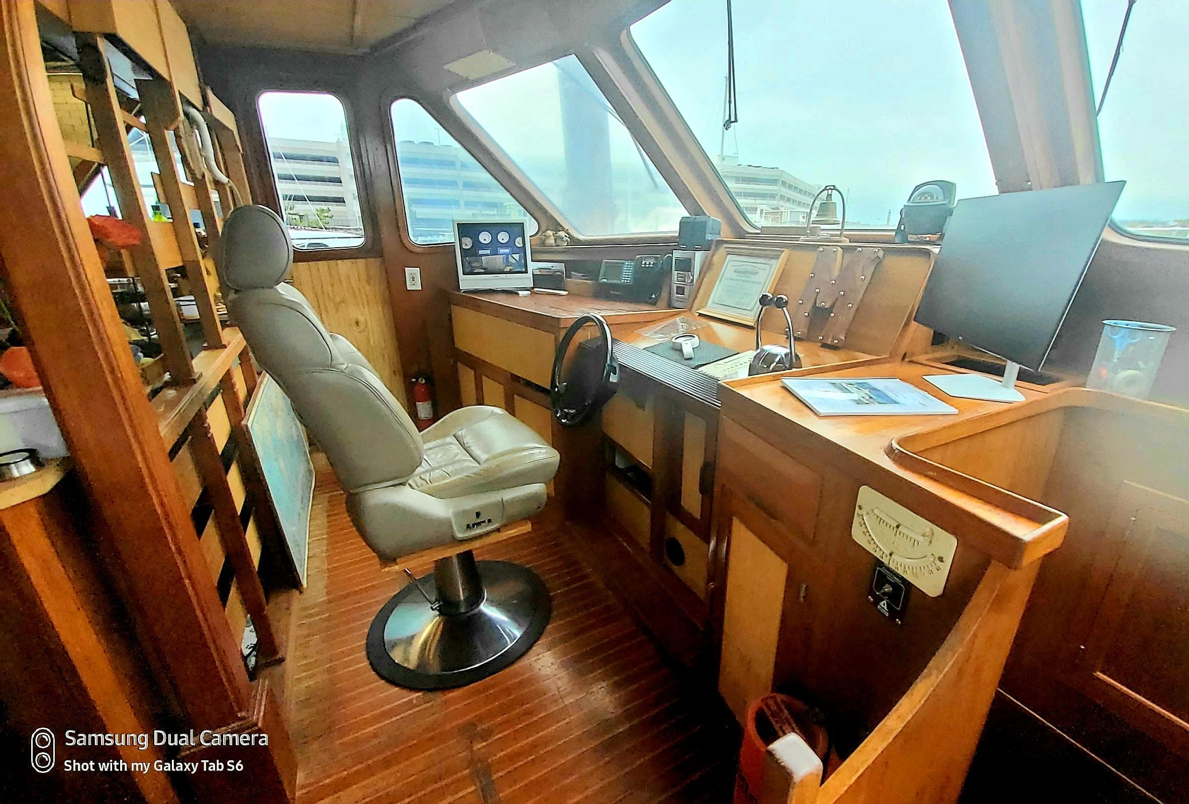 1989 DeFever 57 POC Motor Yacht helm with modern navigation equipment and comfortable captain's chair.