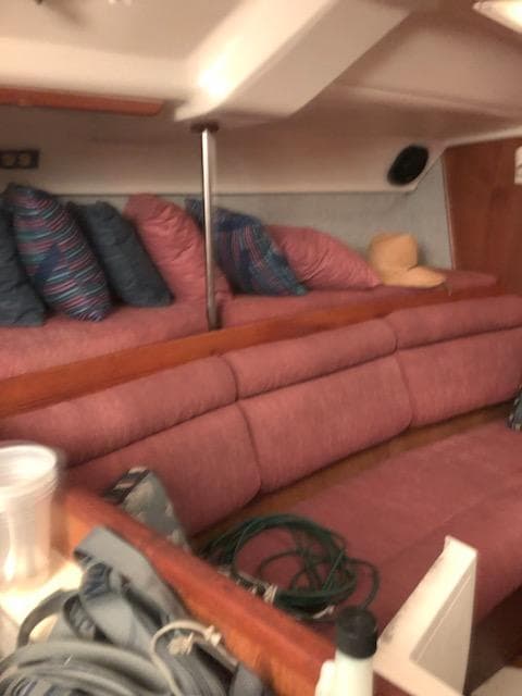 Interior of 1987 Hunter Legend 37 sailboat with pink seating and colorful pillows.