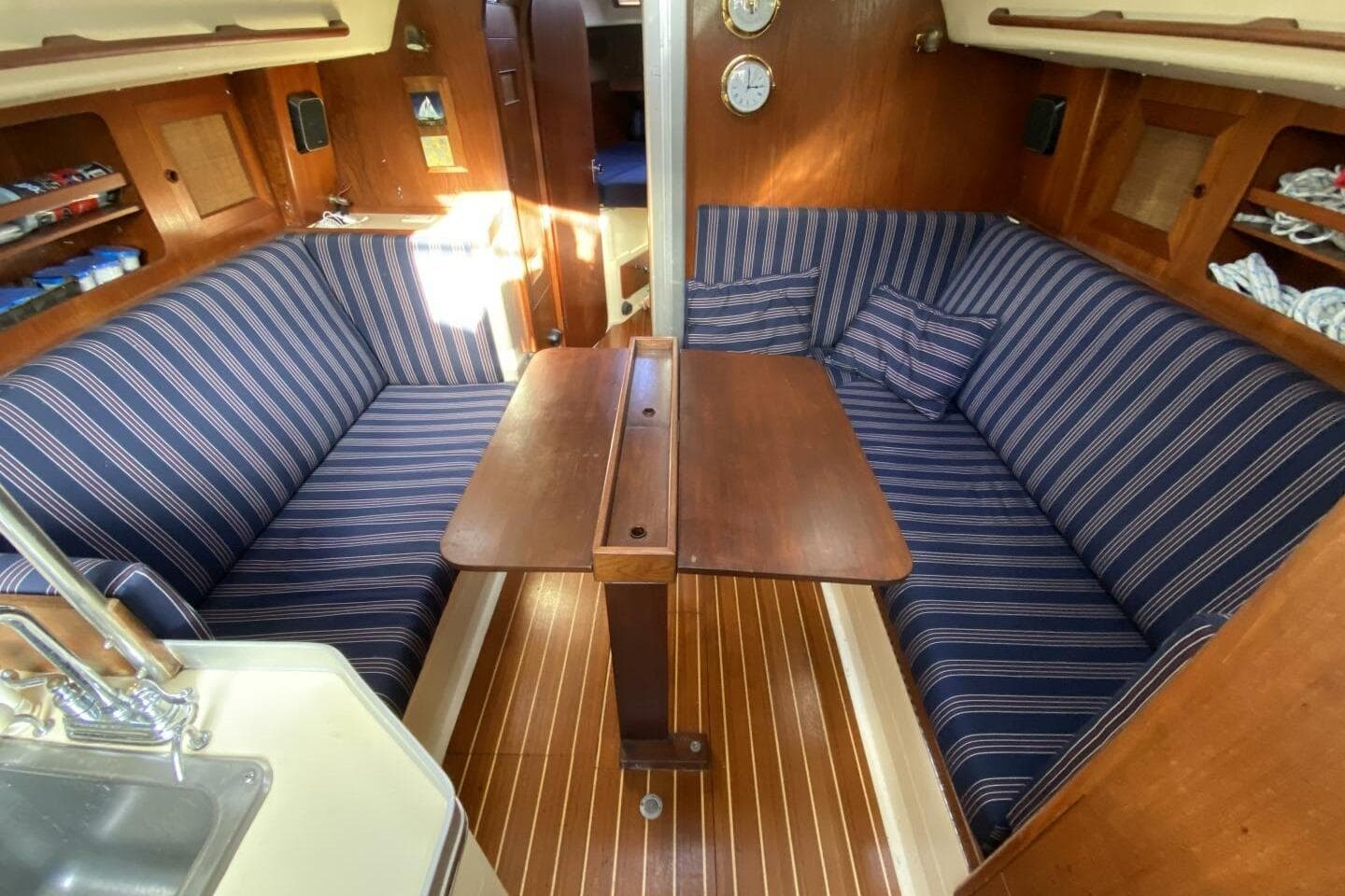 Interior of 1980 CS 36 Traditional sailboat with striped seating and wooden table.