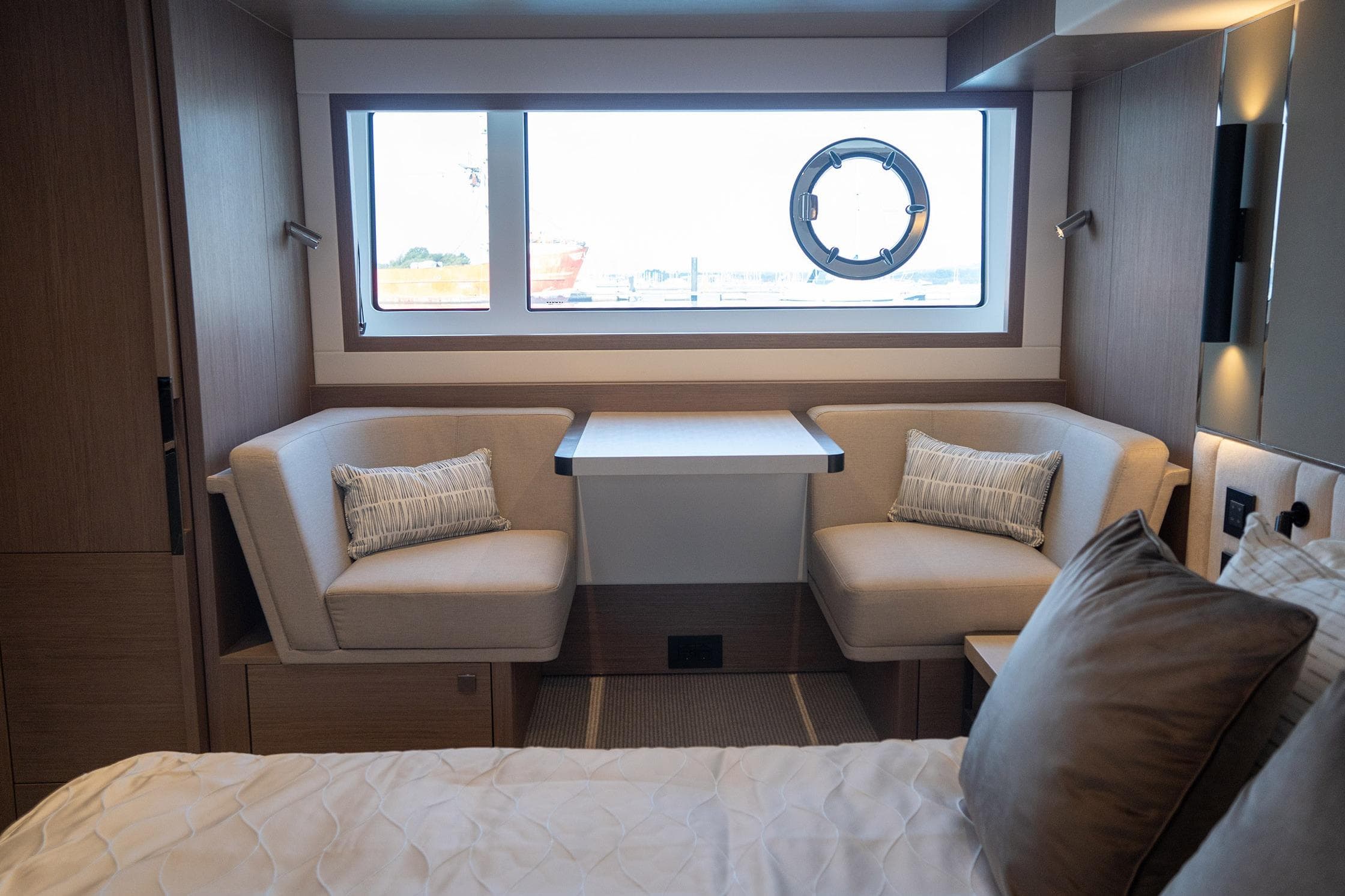 Luxurious interior of 2024 Sunseeker Manhattan 55 yacht with elegant seating and window view.