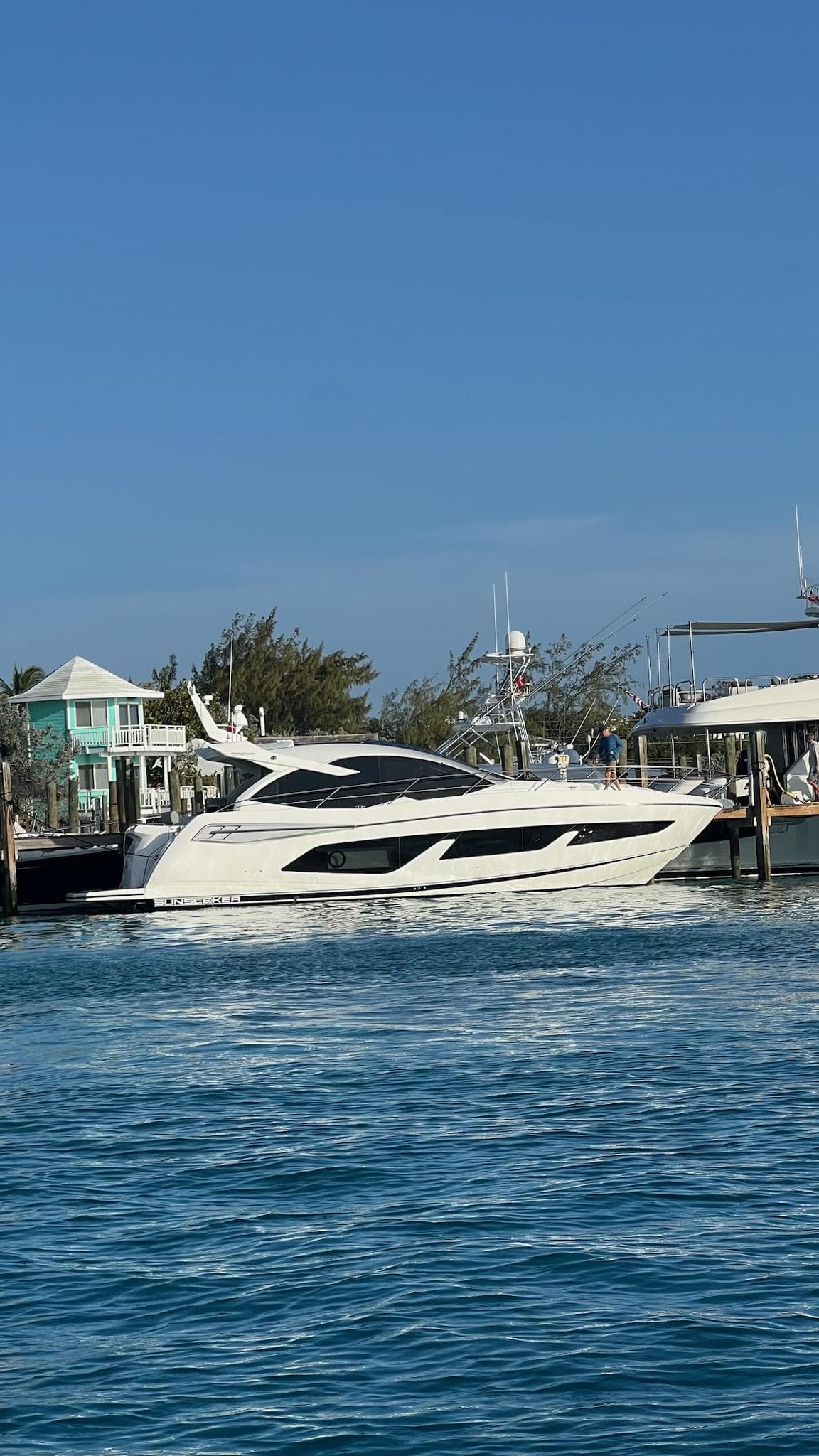 2020 Sunseeker Predator 50 yacht docked in a marina under clear blue skies.