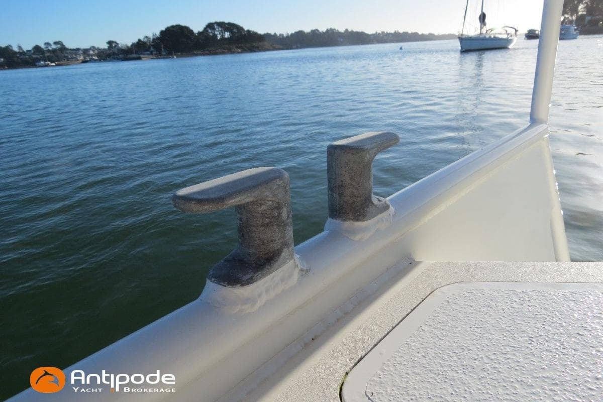 Boat deck with cleats on calm water, featuring Antipode Yacht Brokerage logo.