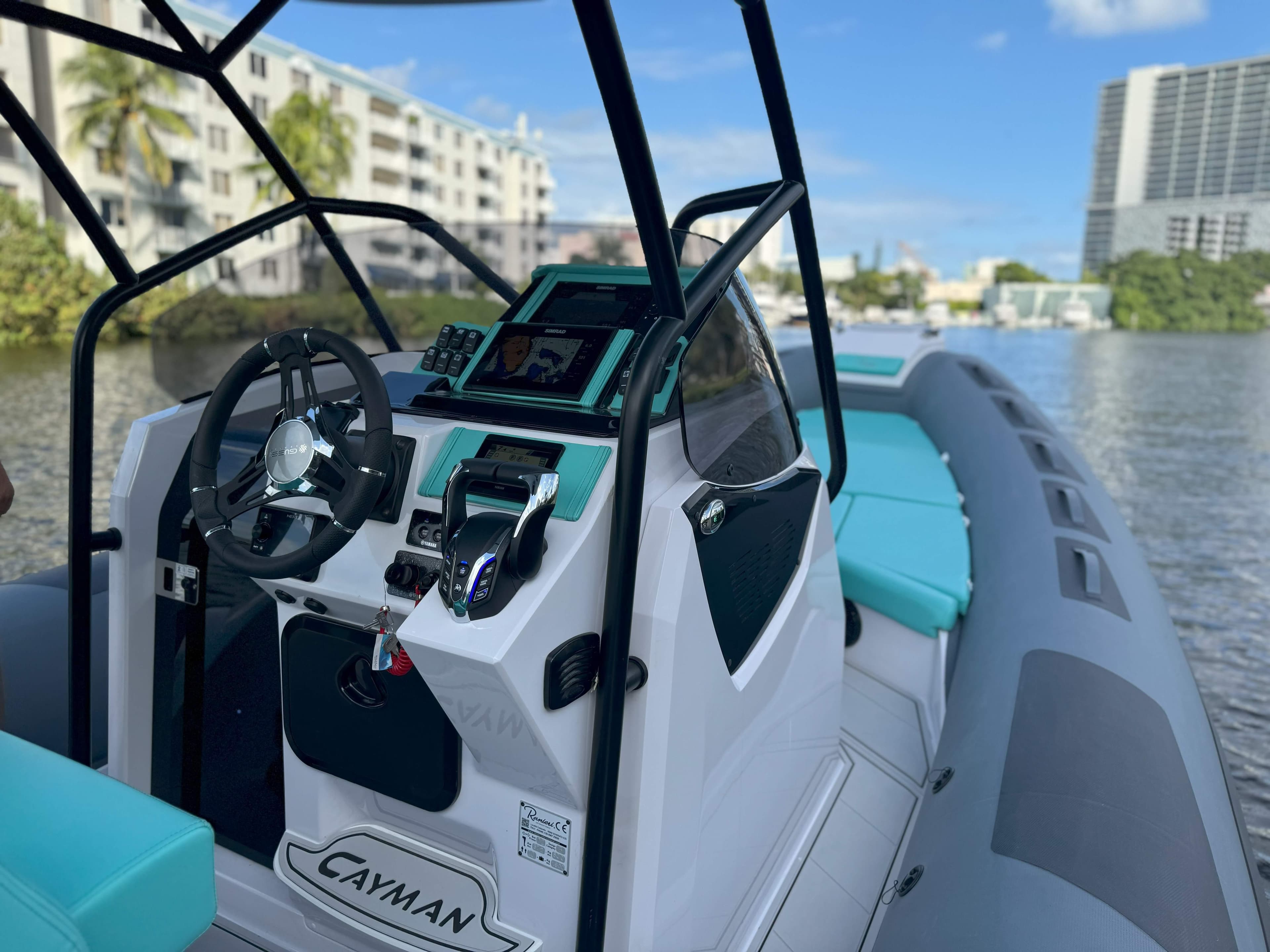 2025 Ranieri CAYMAN 27.0 SPORT TOURING boat interior with modern controls and turquoise seating.