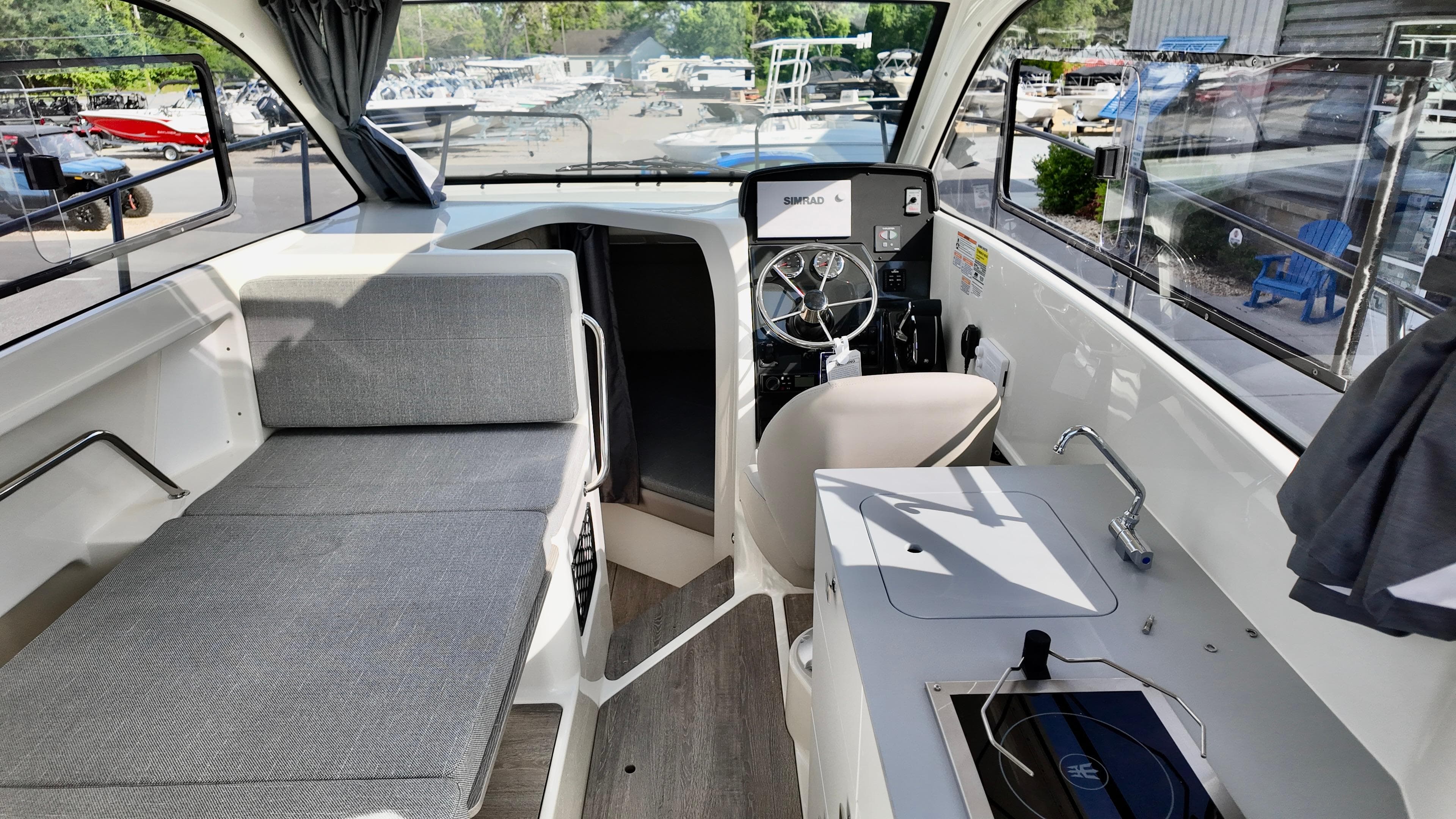 2025 Bayliner TROPHY 25 EXPLORER interior with seating, helm, and kitchenette.