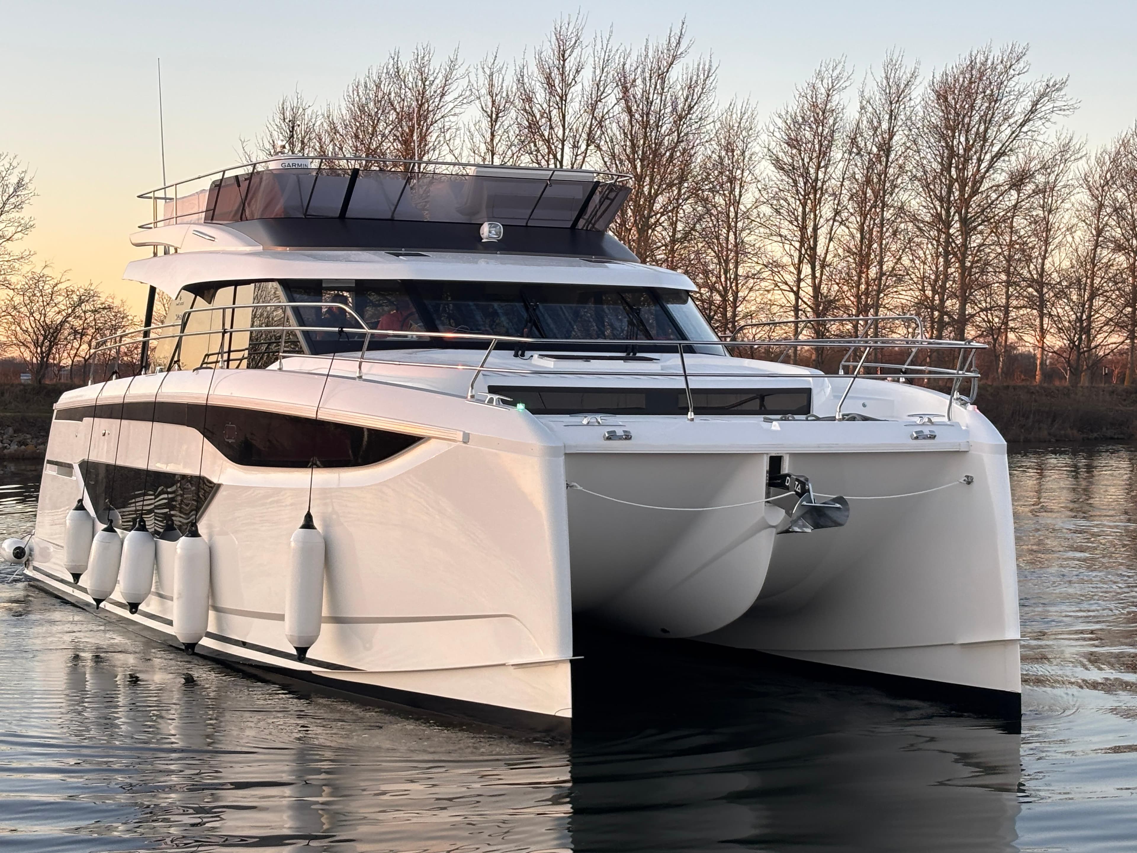 Luxury Prestige M48 yacht, 2025 model, cruising on calm water at sunset.