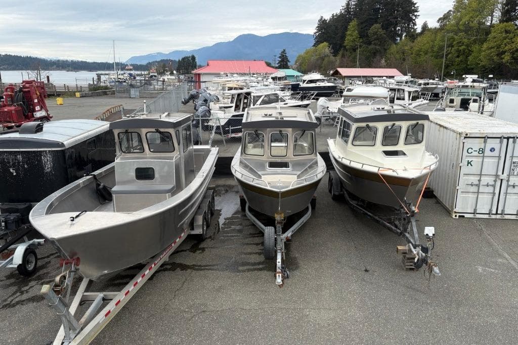 Three Ortun EC276 boats from 2025 on trailers in a marina setting.