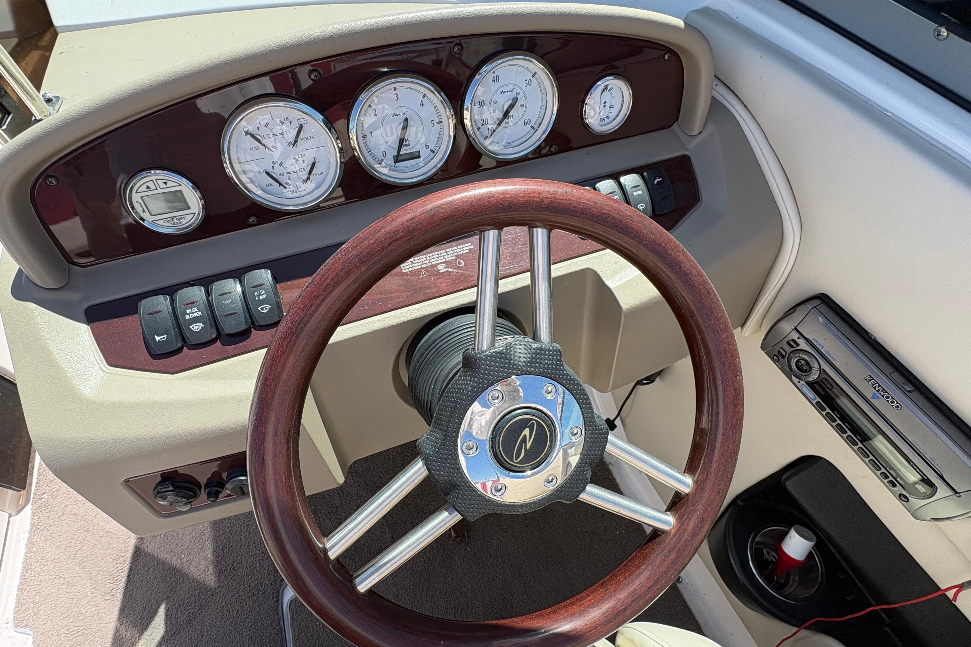 Dashboard of a 2009 Regal 2500 Bowrider boat with wood steering wheel and gauges.