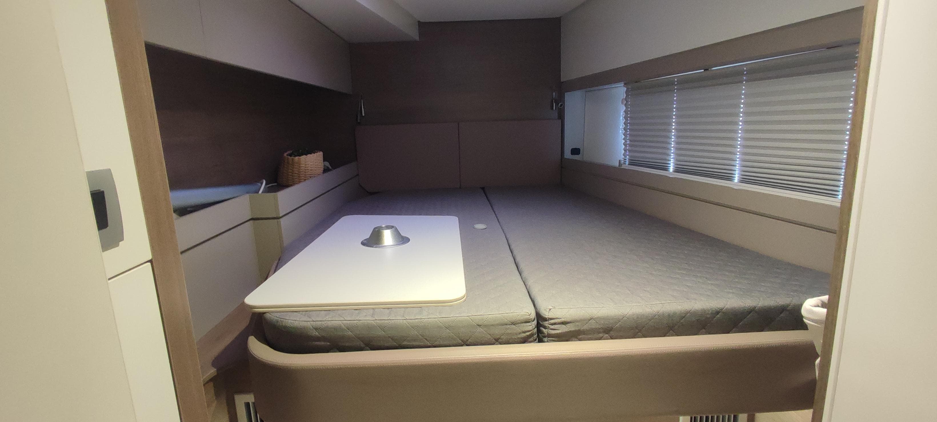 Modern interior of 2023 Bali 4.4 yacht cabin with bed and table.