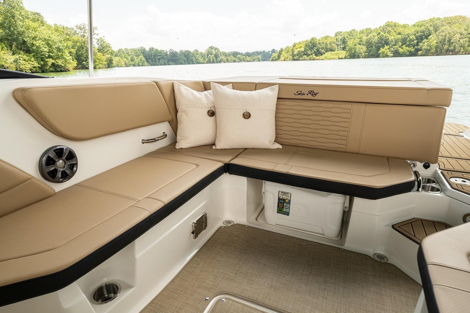 Interior of 2024 Sea Ray SPX 230 with beige upholstery and cushions.