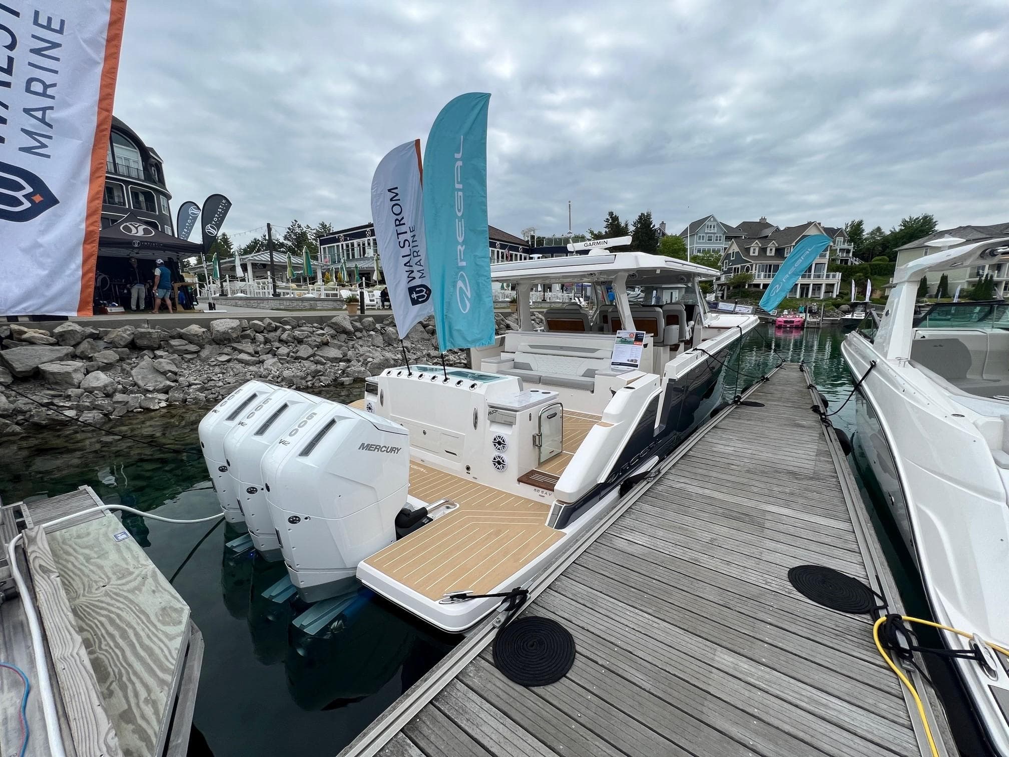 2026 Regal 50 SAV yacht docked, featuring powerful Mercury outboard engines.