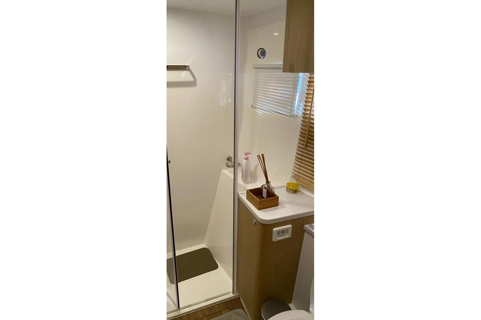 Modern bathroom interior in 2023 Aquila 42 yacht, featuring shower and wooden accents.