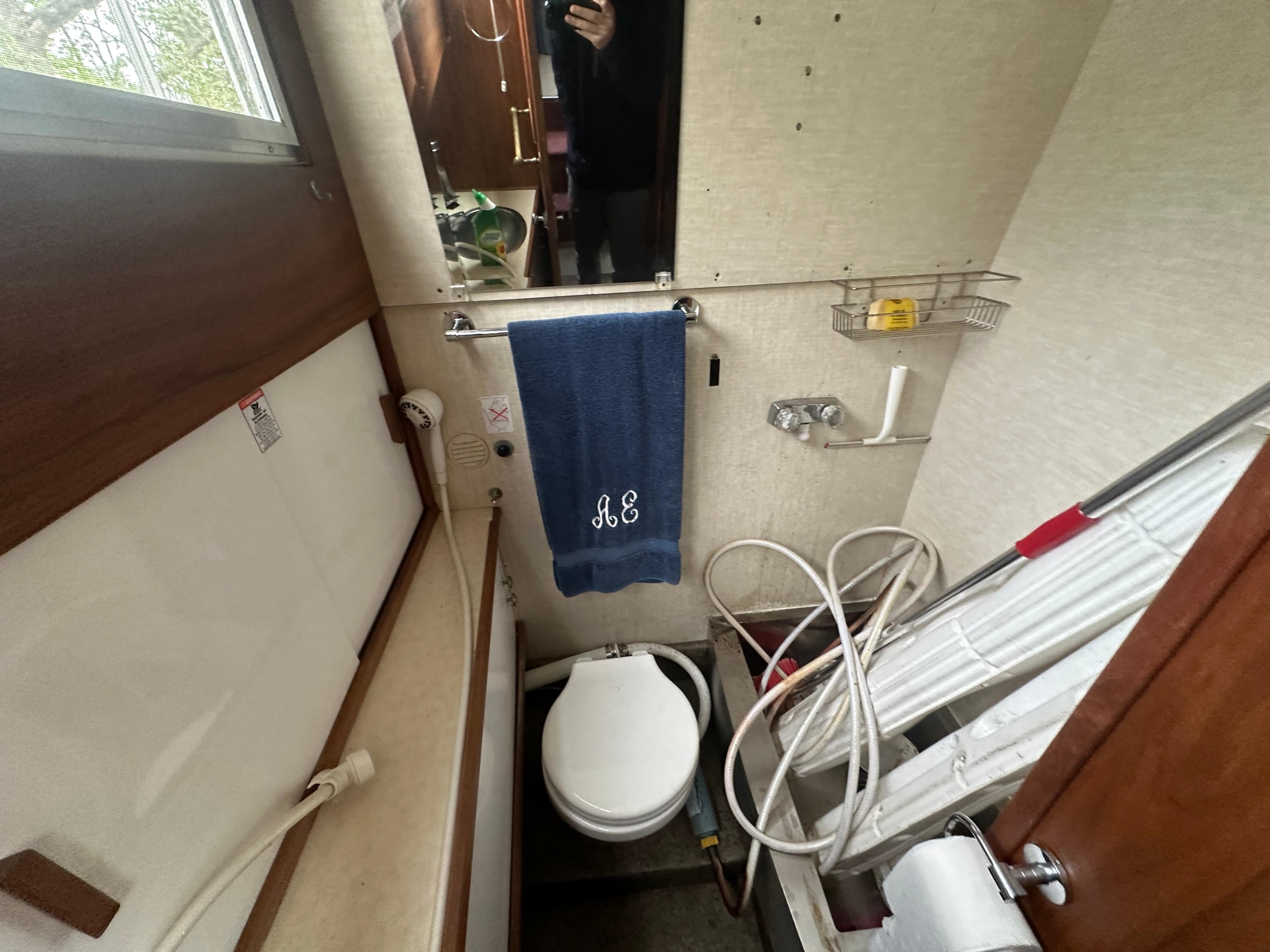 1979 Chris-Craft 350 Catalina bathroom with toilet, towel, and storage.