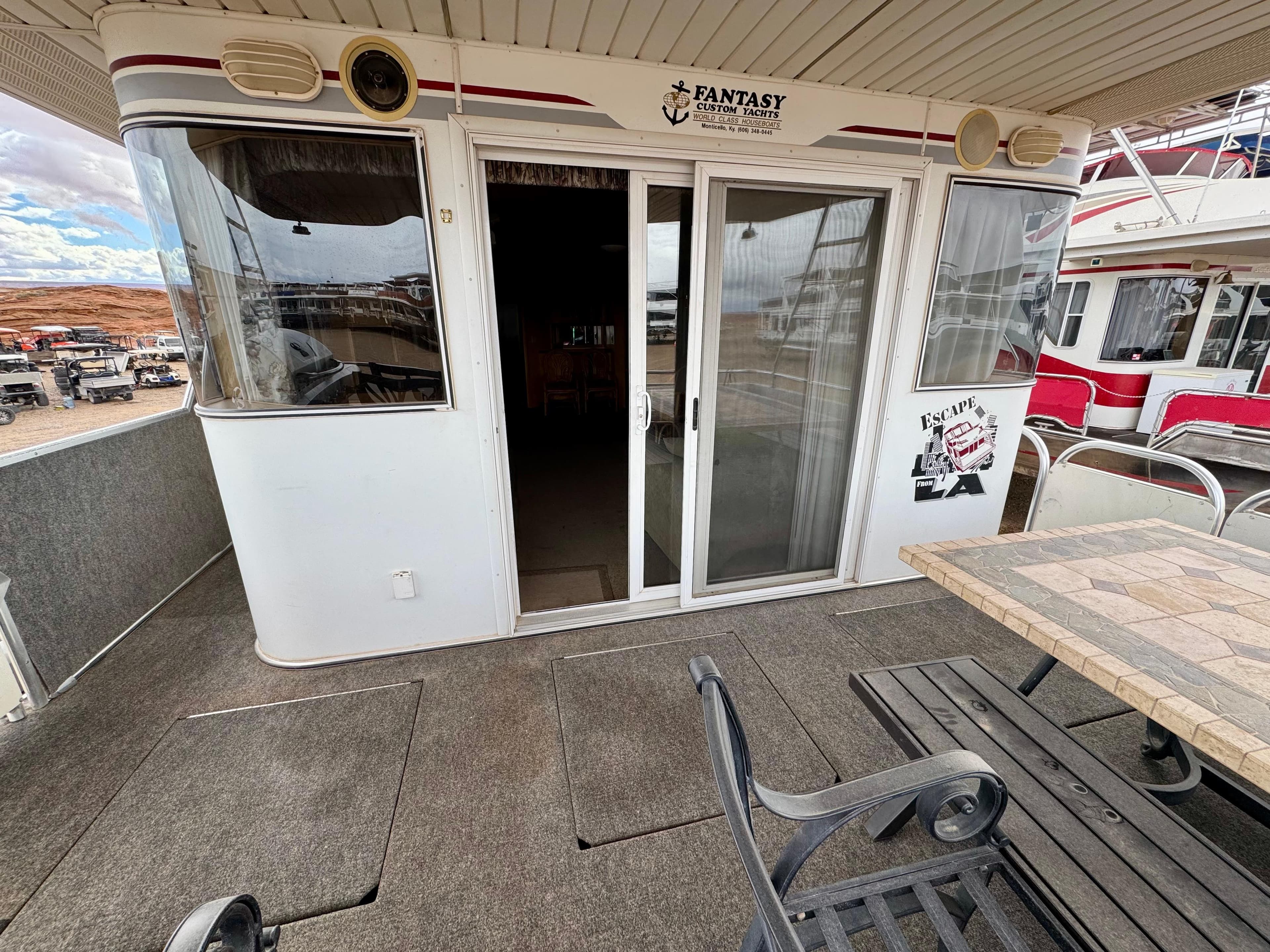 Houseboat deck with sliding doors, labeled "Fantasy Escape From LA," featuring outdoor seating.