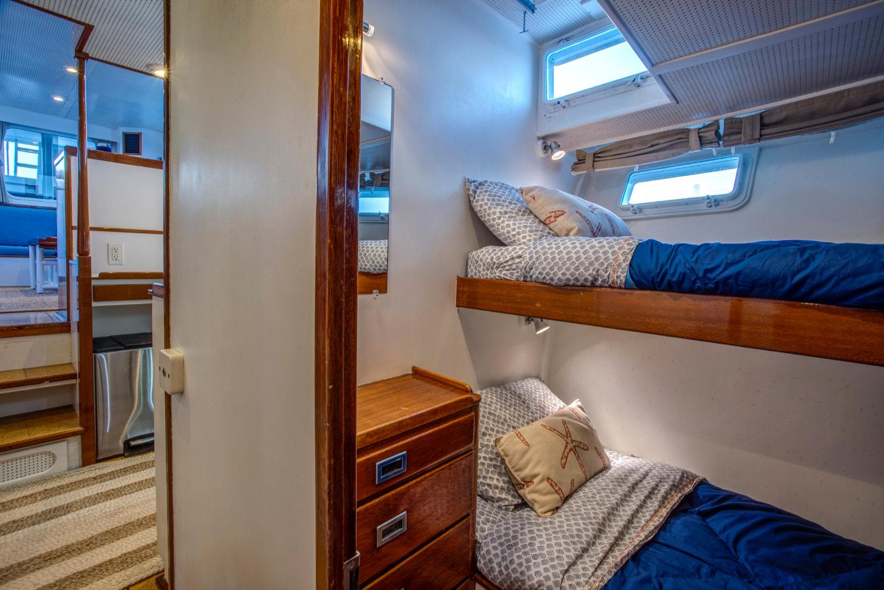 Interior of 1964 Huckins Out Islander 56 yacht with cozy bunk beds and wooden cabinetry.