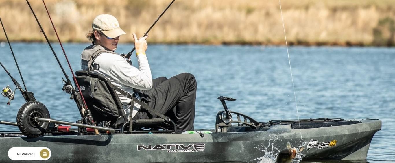 Angler fishing from a 2023 Native Watercraft Propel 12.5 Max kayak on a calm lake.