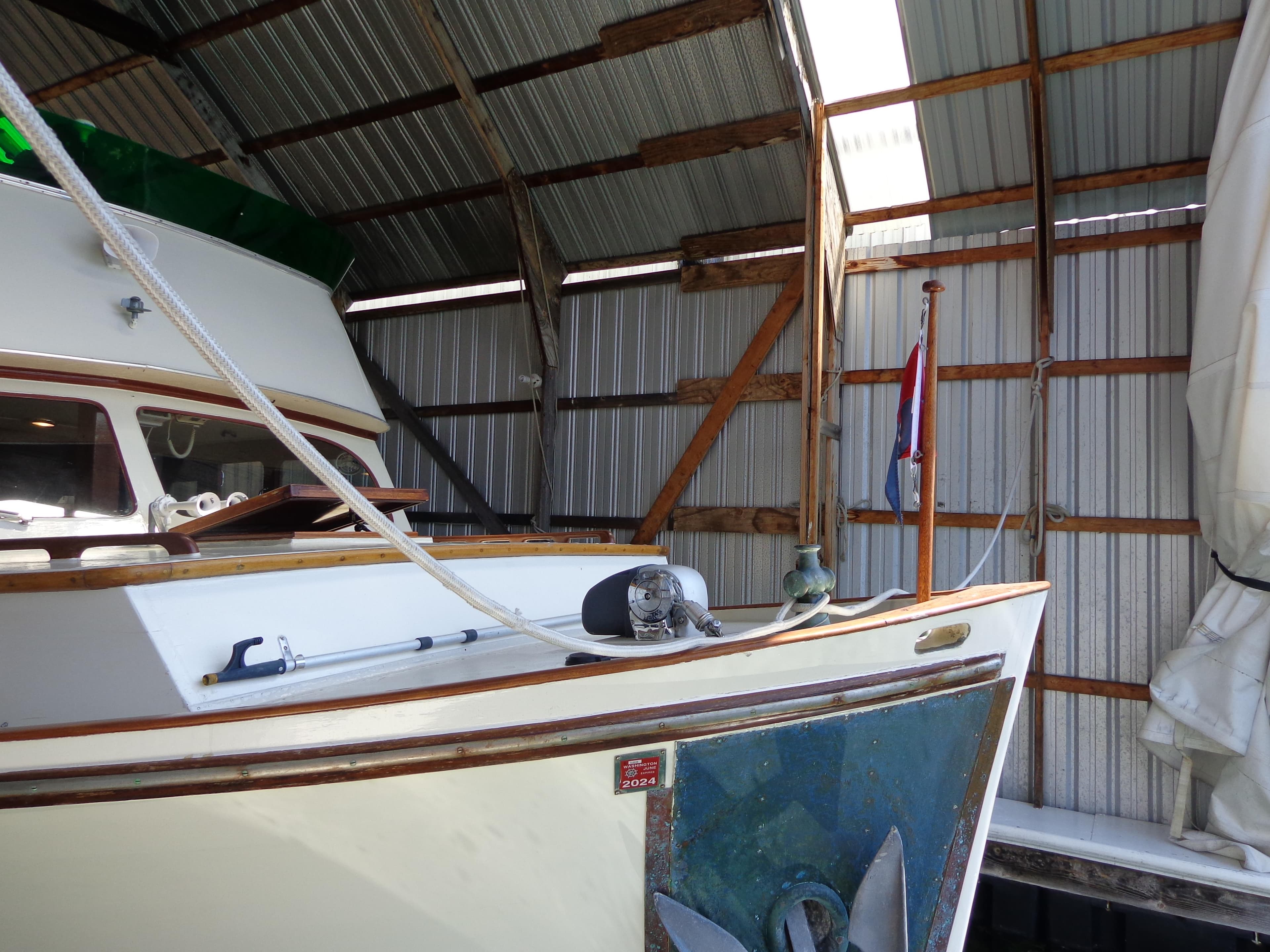 1946 Monk Flybridge Sedan boat docked in a covered marina.