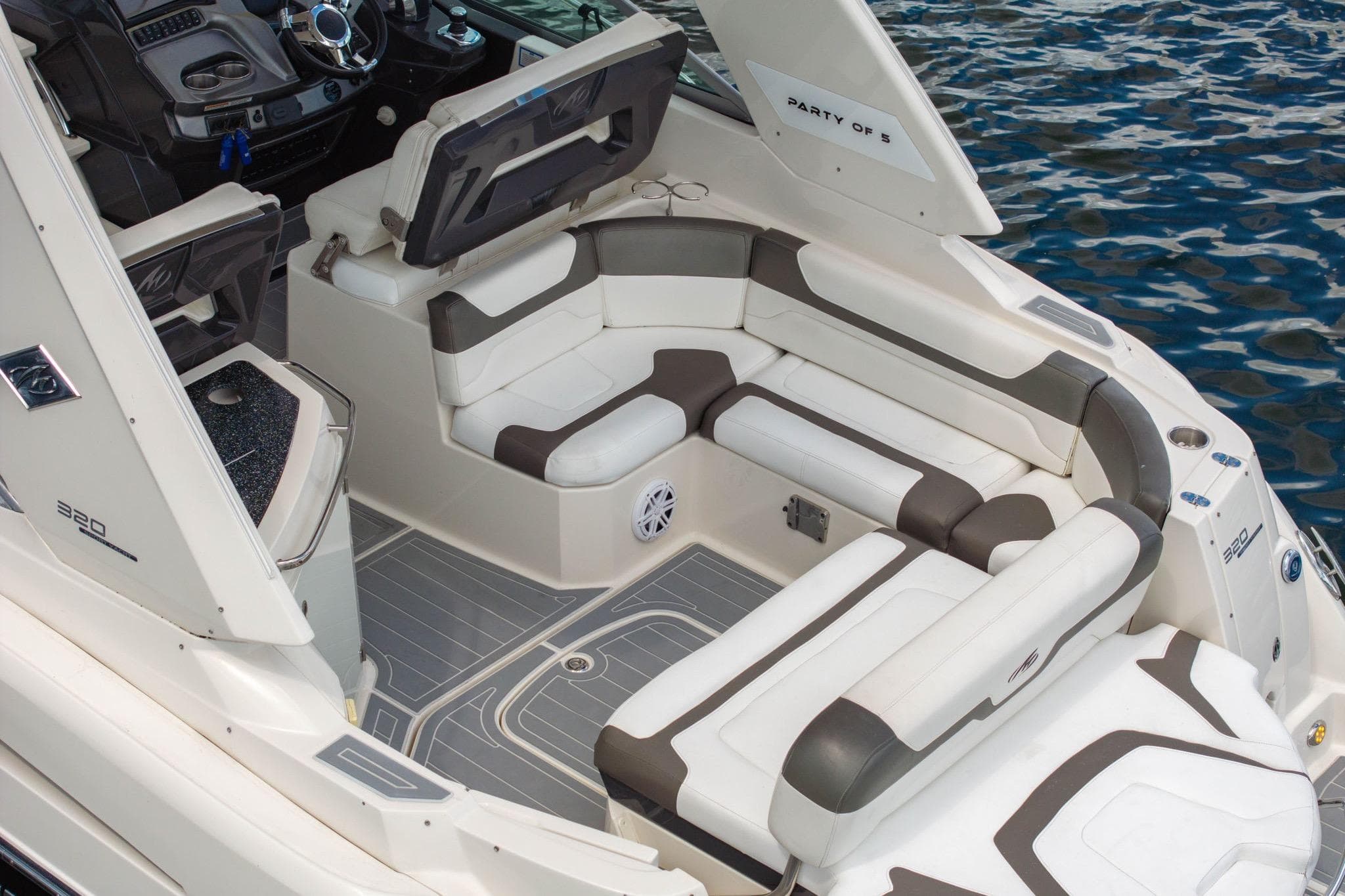 2014 Monterey 320 Sport Yacht interior with plush seating and modern dashboard on water.