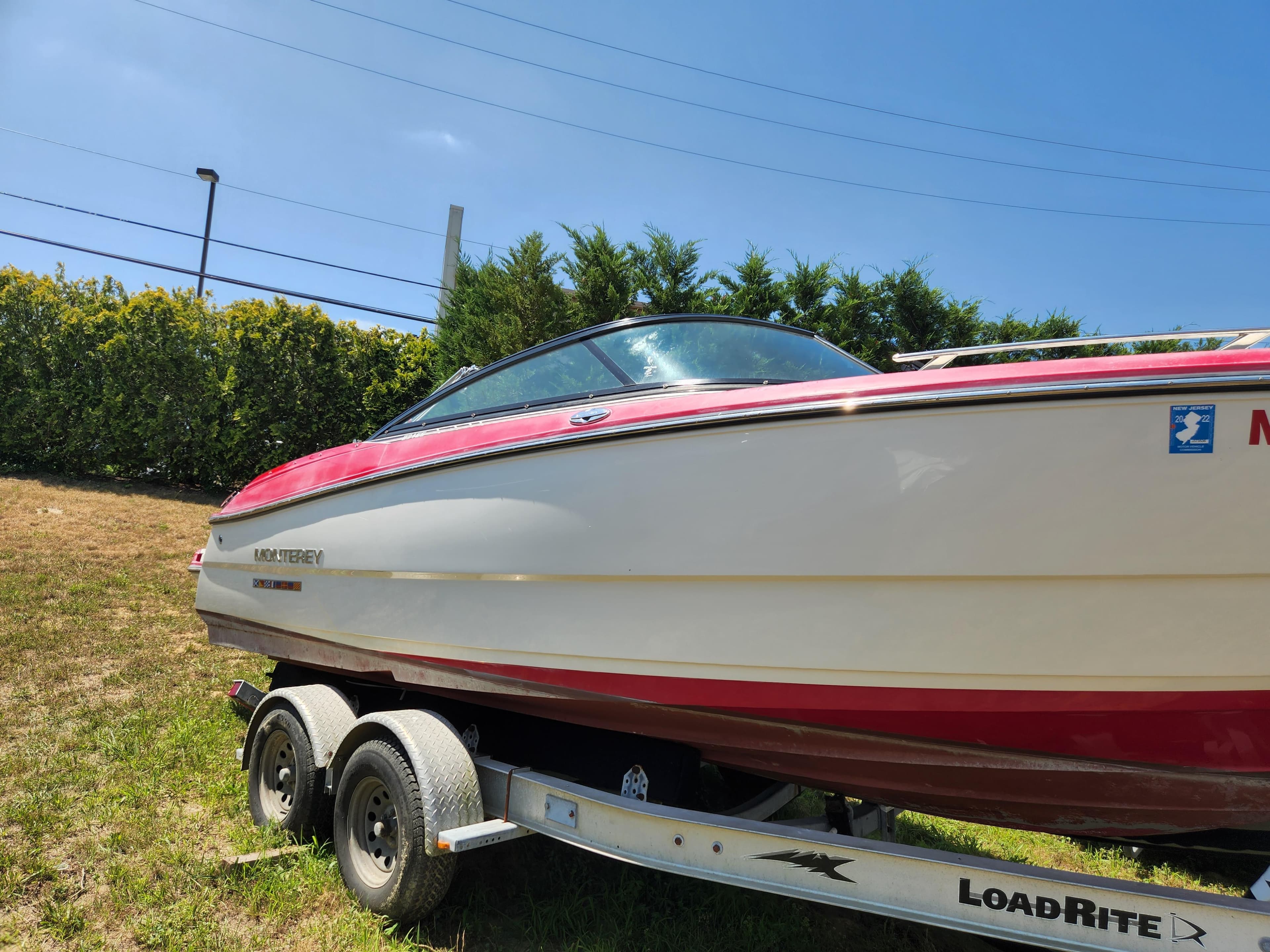 2014 Monterey 234 SS boat on LoadRite trailer, red and white exterior.