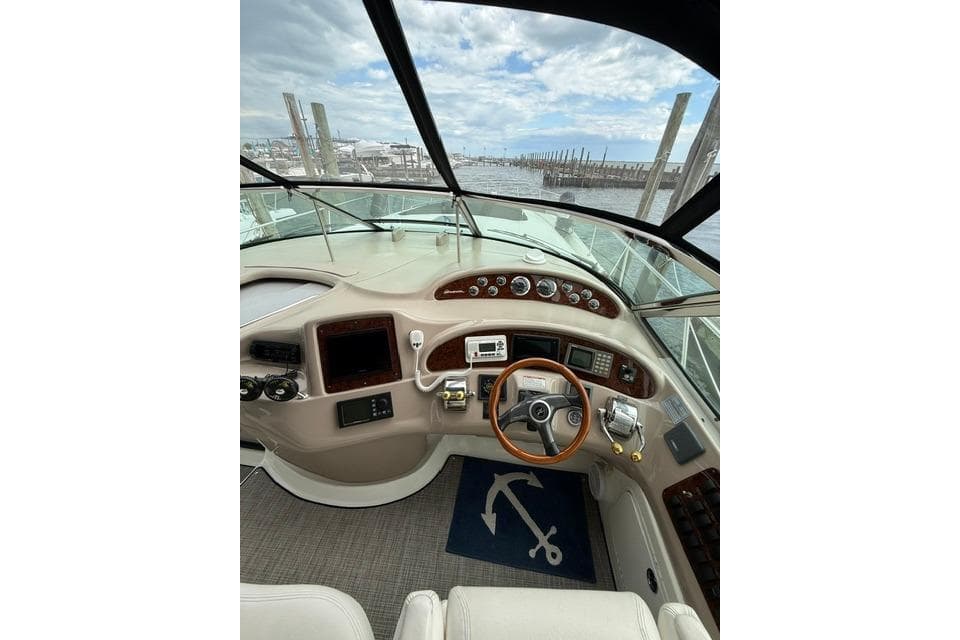 Cockpit view of 2000 Sea Ray Sundancer 460 yacht with steering wheel and control panel.