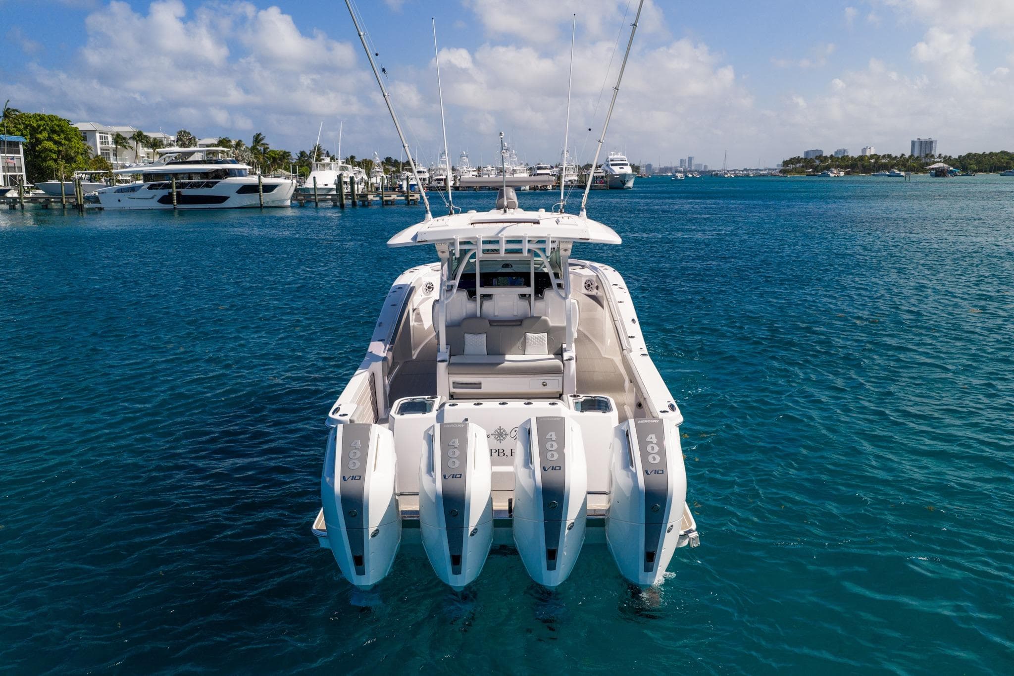 2024 Scout 400 LXF boat with four powerful engines on clear blue water.