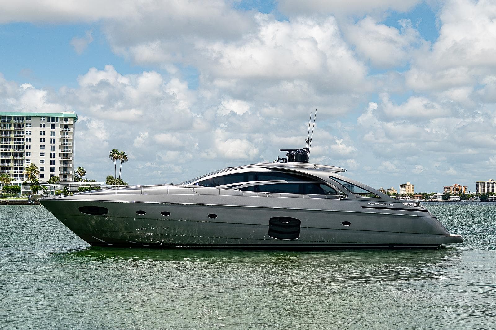 2015 Pershing 70 yacht on calm water with cityscape background.