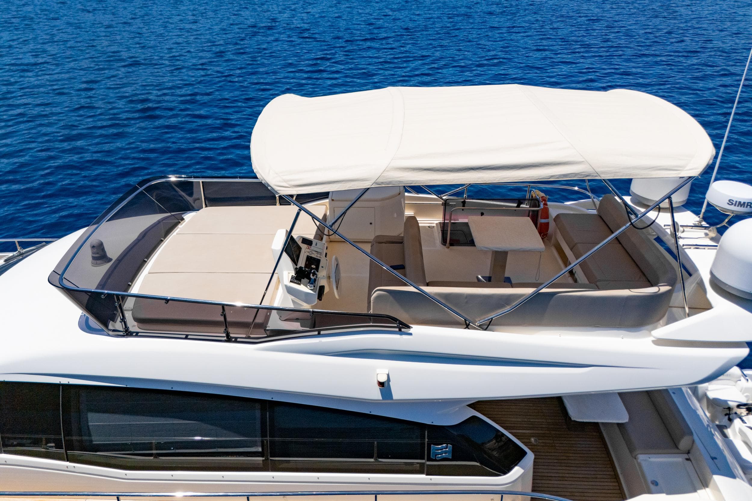 2021 Ferretti Yachts 550 flybridge with canopy, cruising on blue ocean waters.
