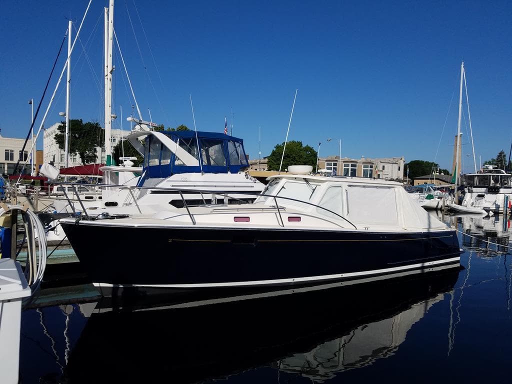 2013 MJM 36z Downeast boat docked in a marina under clear blue skies.