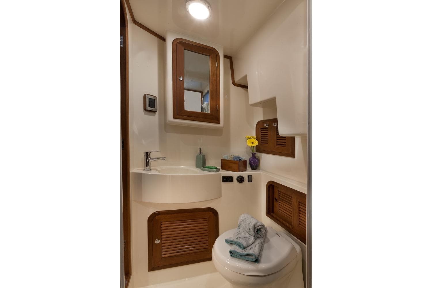 Compact bathroom in 2026 Helmsman Trawlers 43 Pilothouse, featuring sink, mirror, and storage.