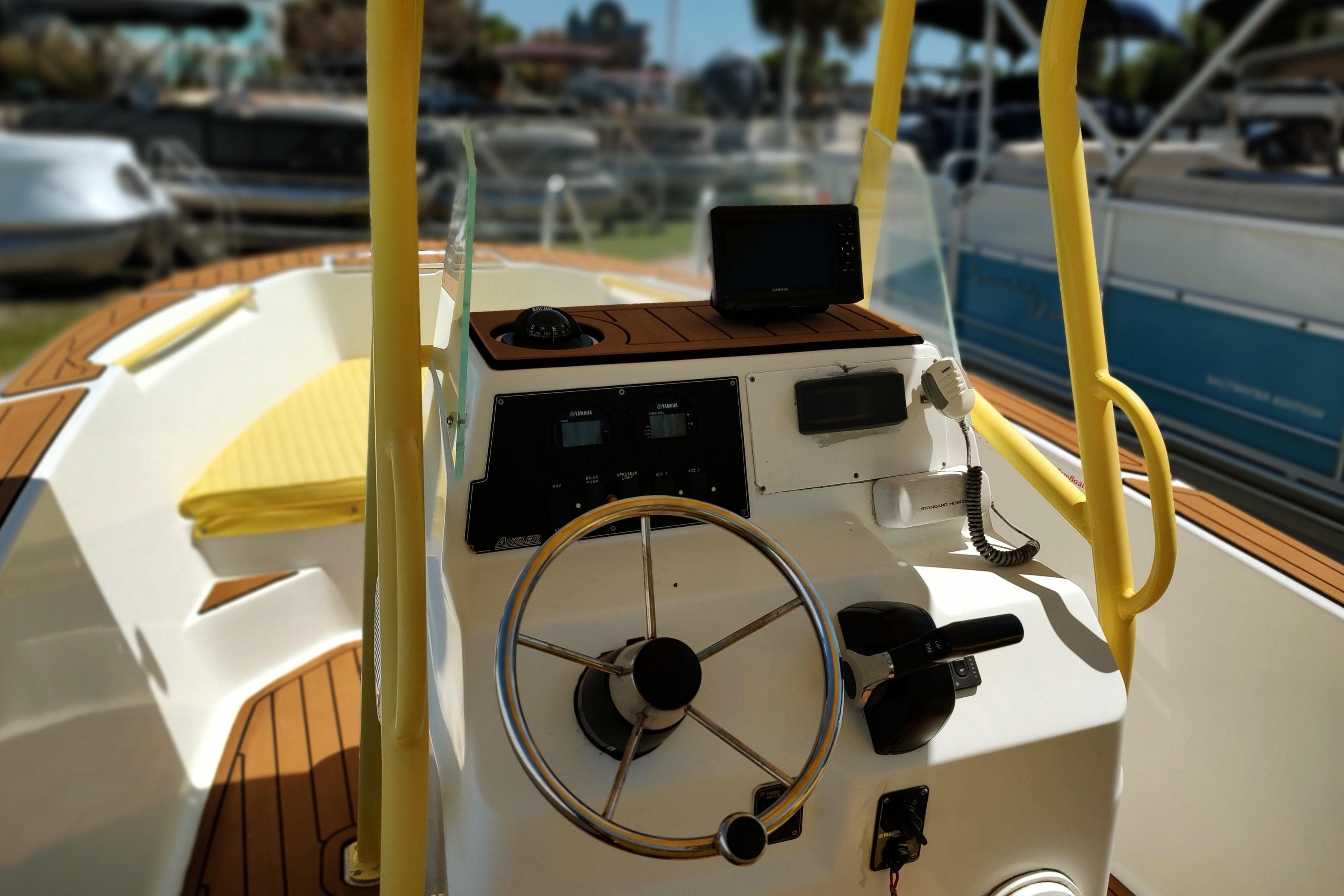 2004 Angler 204 Center Console boat interior with steering wheel and navigation equipment.
