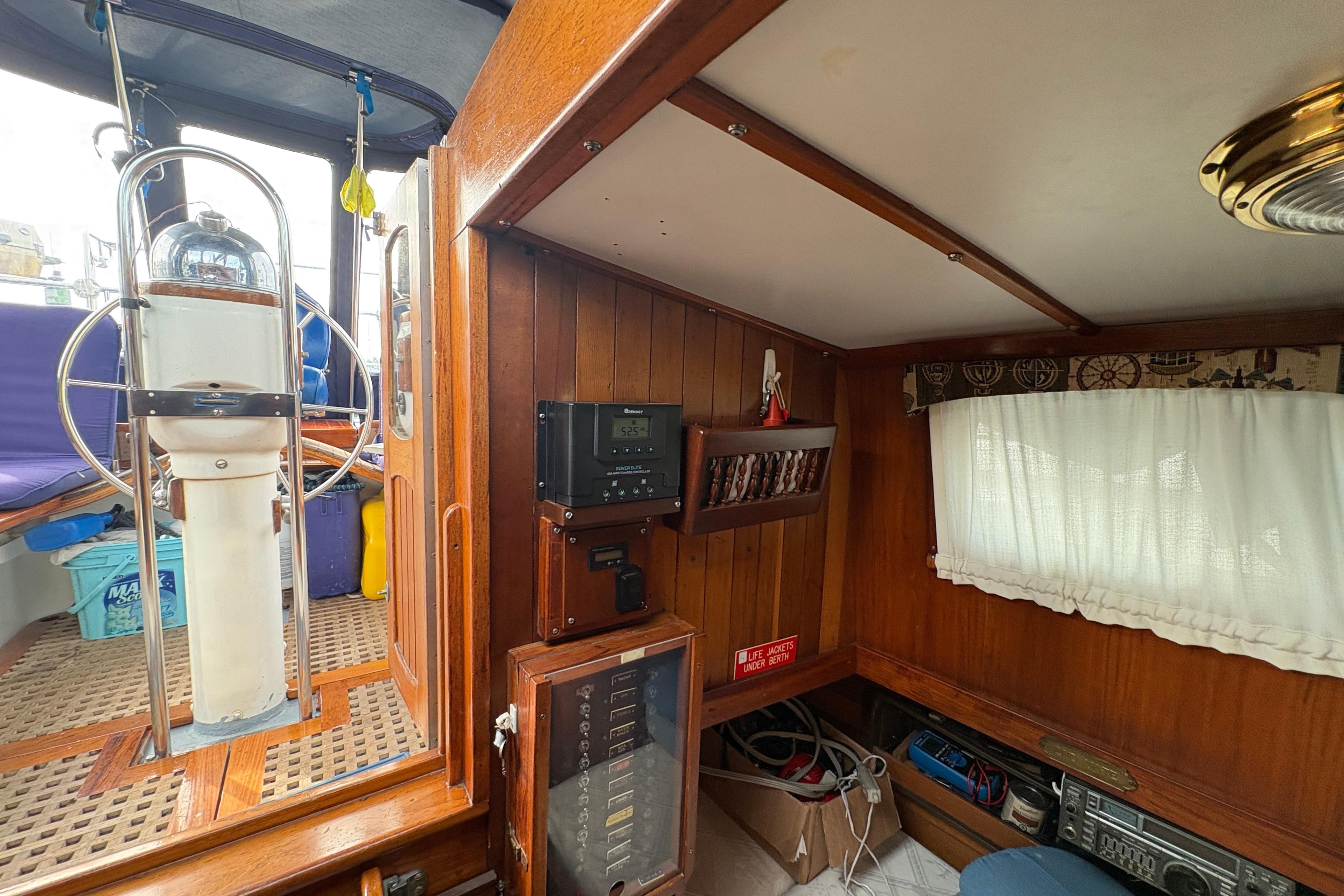 Interior of a 1977 Folkes Full Keel Offshore Cutter, featuring wooden paneling and nautical equipment.
