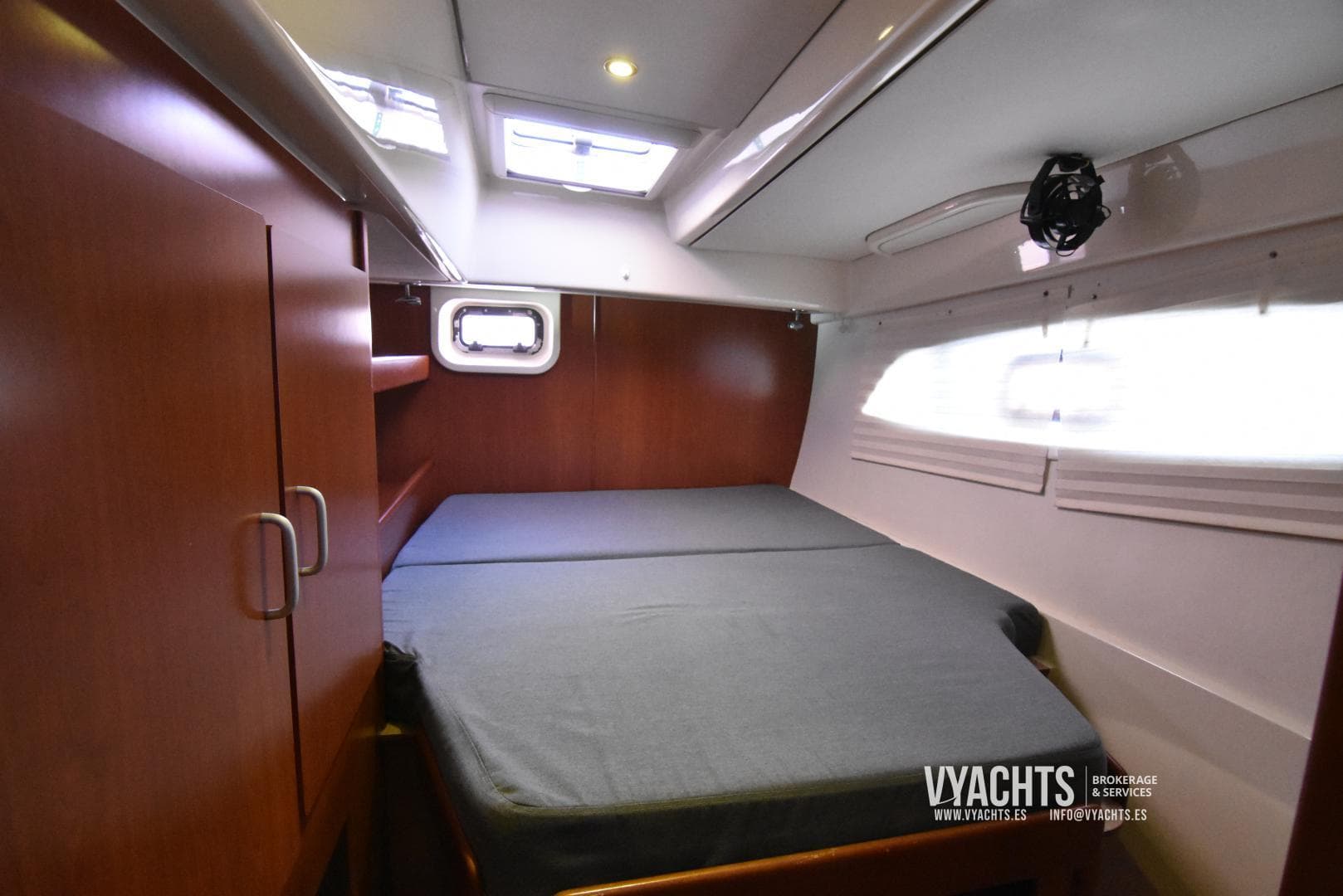 Cozy cabin interior of 2012 Leopard 44 yacht with bed and wooden cabinetry.