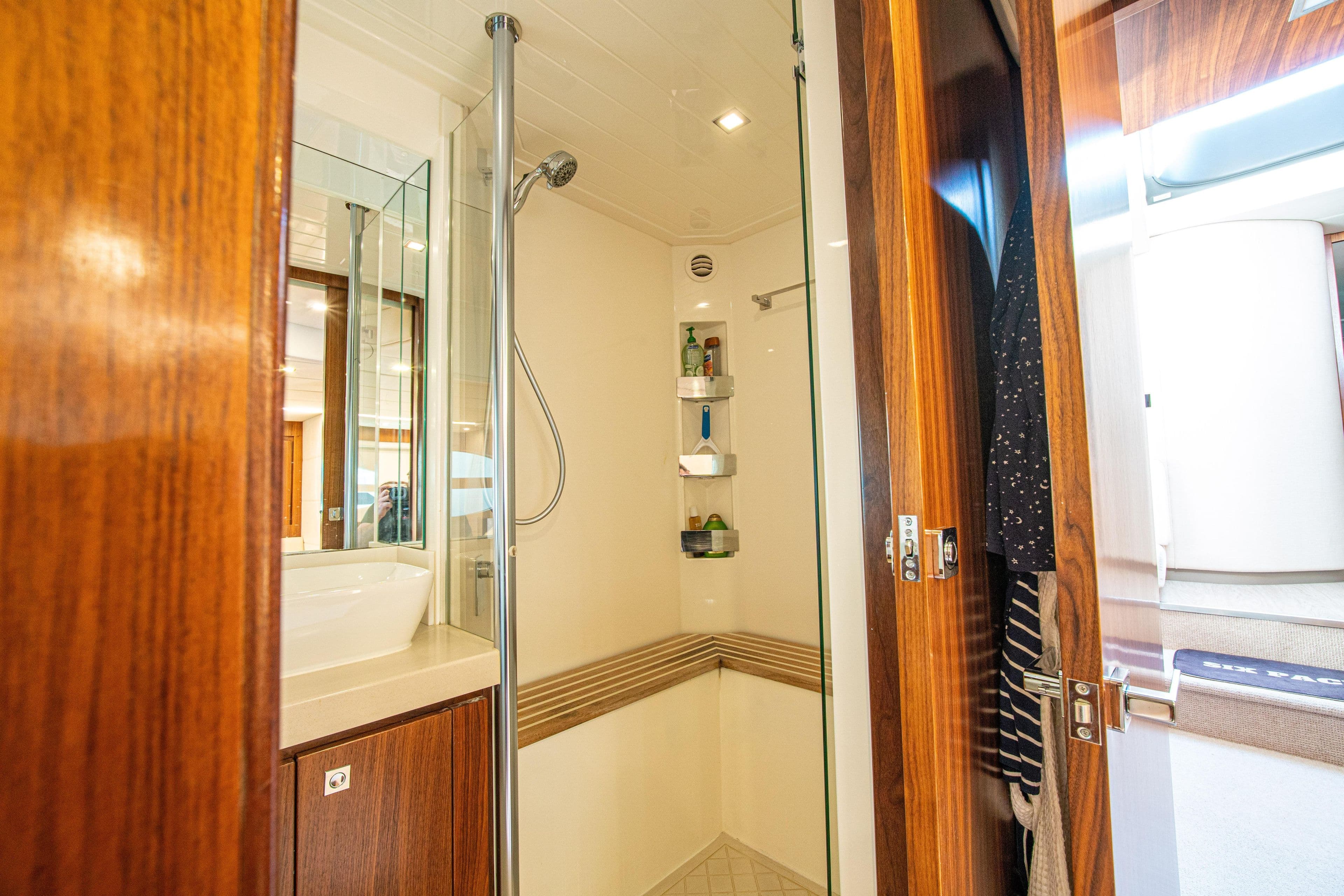 Luxurious bathroom interior of 2015 Riviera 6000 Sport Yacht with wooden accents.