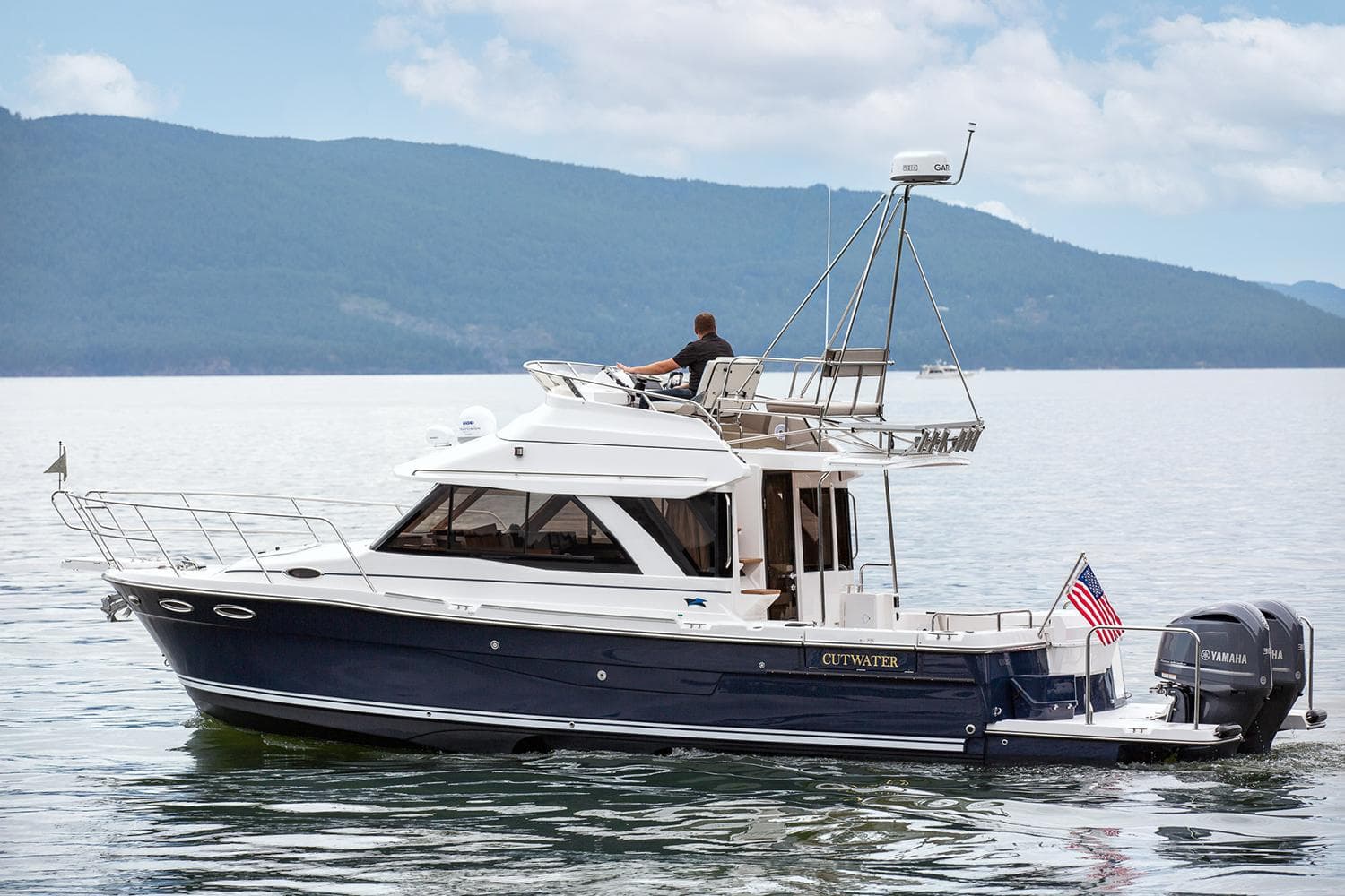 Manufacturer Provided Image: 2025 Cutwater C-32 CB boat cruising on a serene lake with mountains in the background.