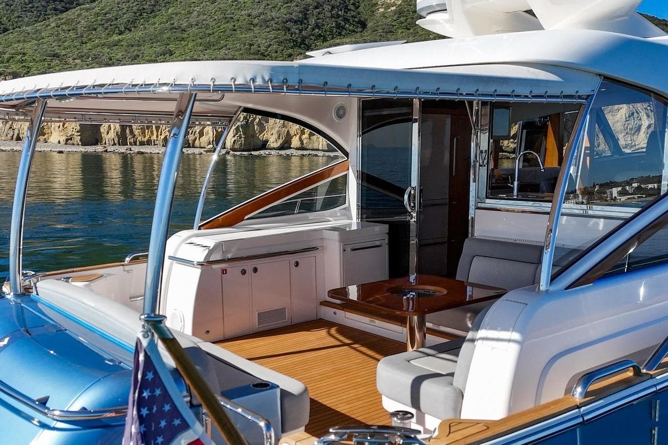 2019 Belize 66 Sedan yacht interior with elegant seating and scenic coastal backdrop.