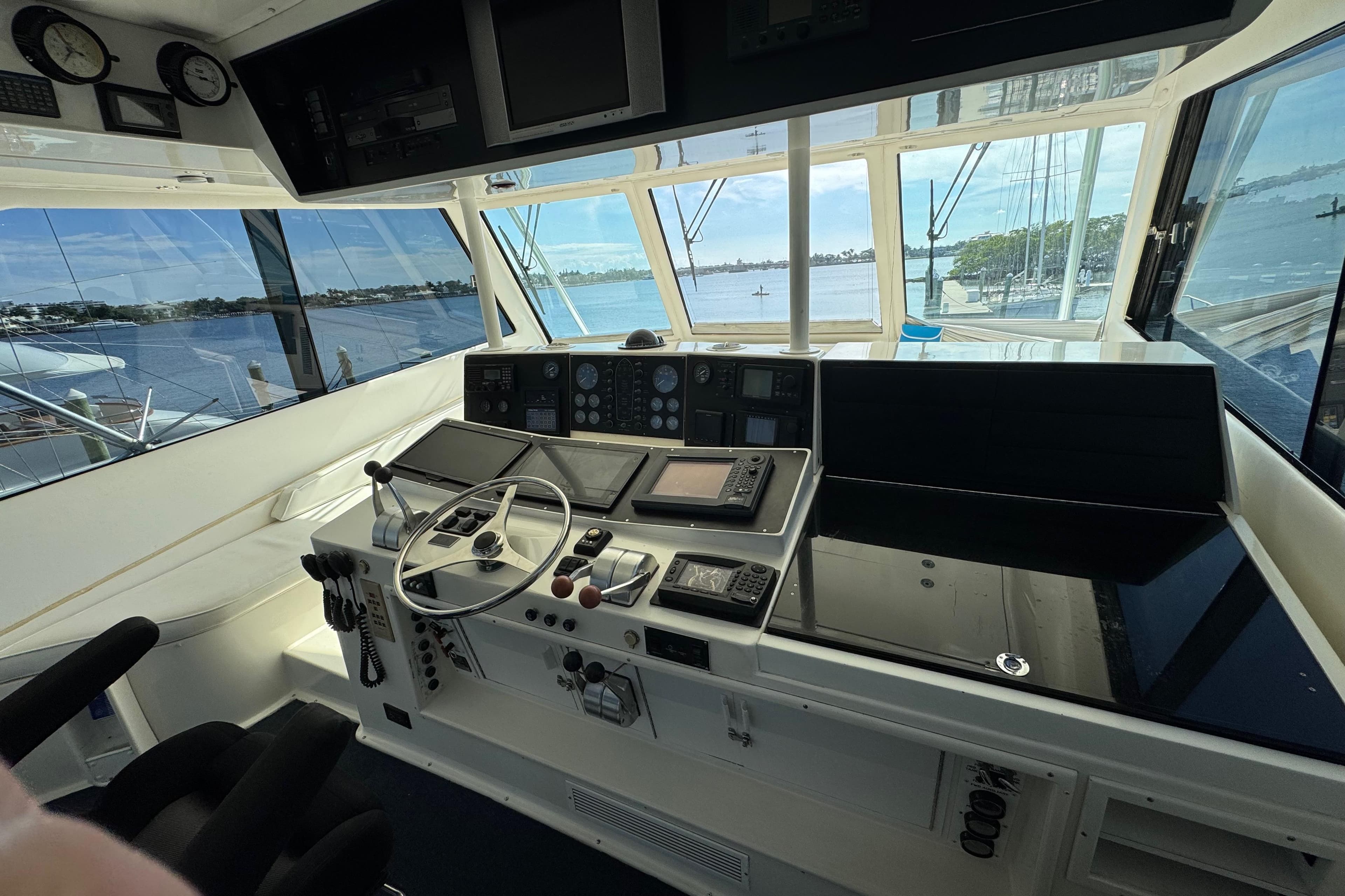 Cockpit of 1995 Viking 58 Convertible yacht with navigation instruments and scenic water view.