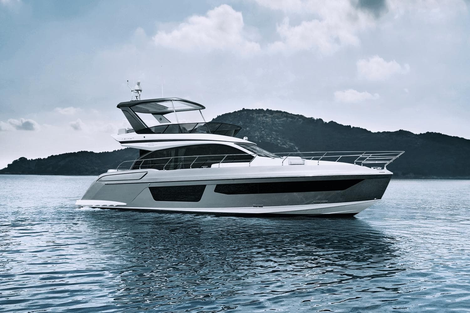 2024 Azimut 53 Fly yacht on calm water with scenic mountain backdrop.