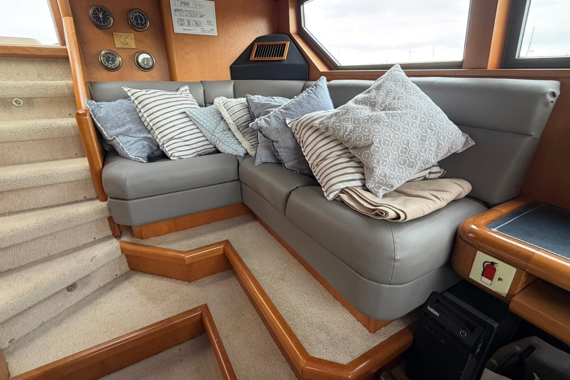 Cozy interior of 1990 Lowland Netship 97 yacht with plush cushions and elegant wood accents.