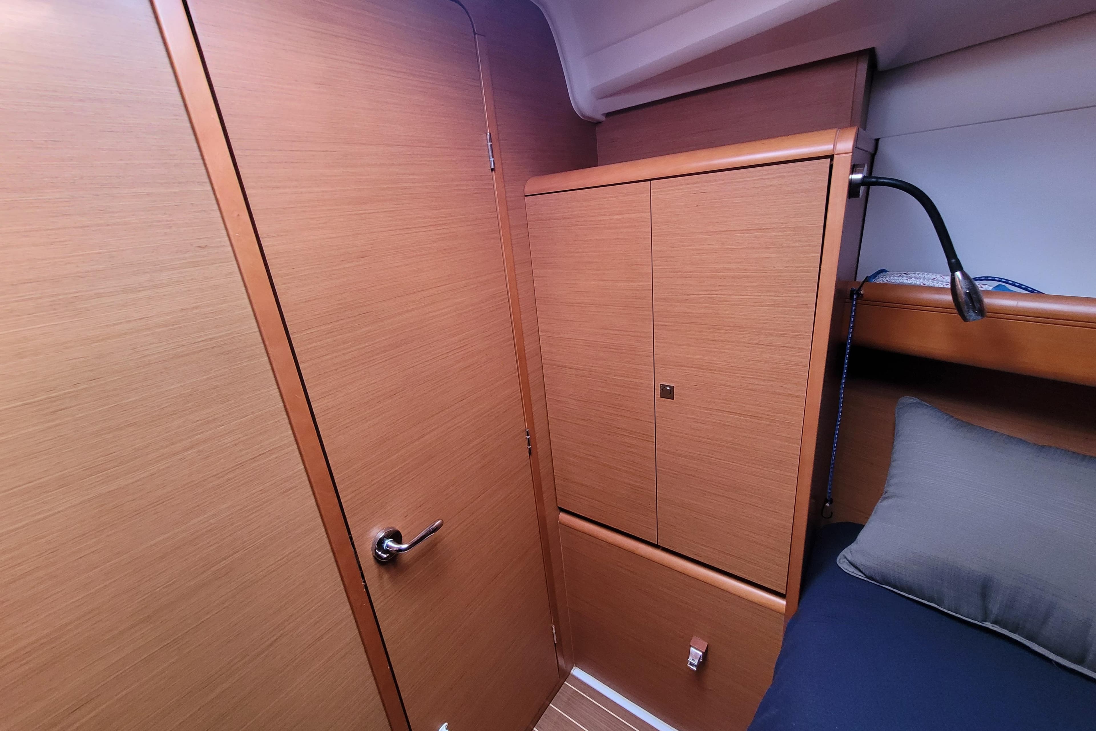2014 Jeanneau 379 interior cabin with wooden cabinetry and cozy bedding.