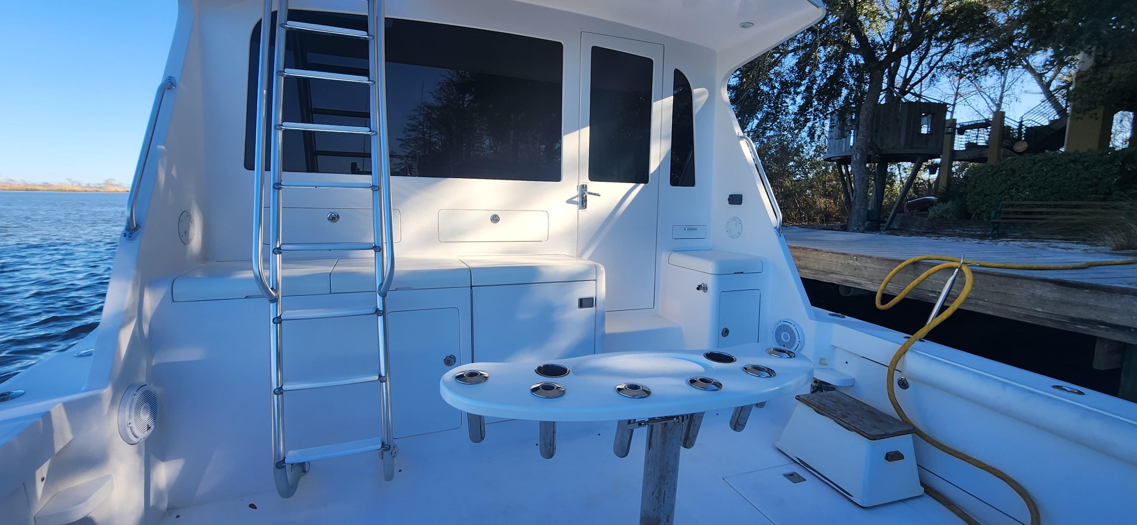 2004 Cabo 48 Convertible yacht deck with ladder and fishing rod holders.