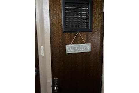 Wooden door with "Salle de Bain" sign on a 1967 Hatteras 44 Tri Cabin yacht.