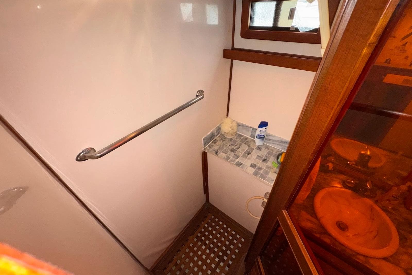 Compact bathroom in 1988 Jefferson 52 Monticello yacht with sink and shower area.