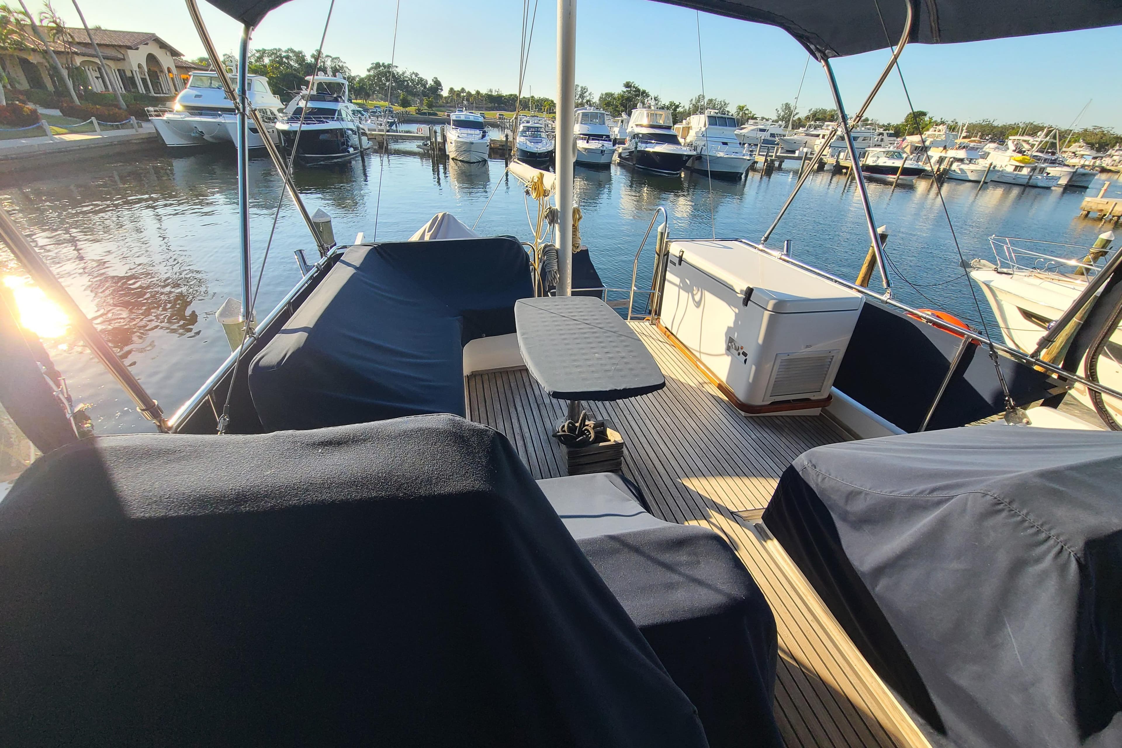 Grand Banks 46 Classic yacht deck, 2000 model, docked at marina with covered seating.
