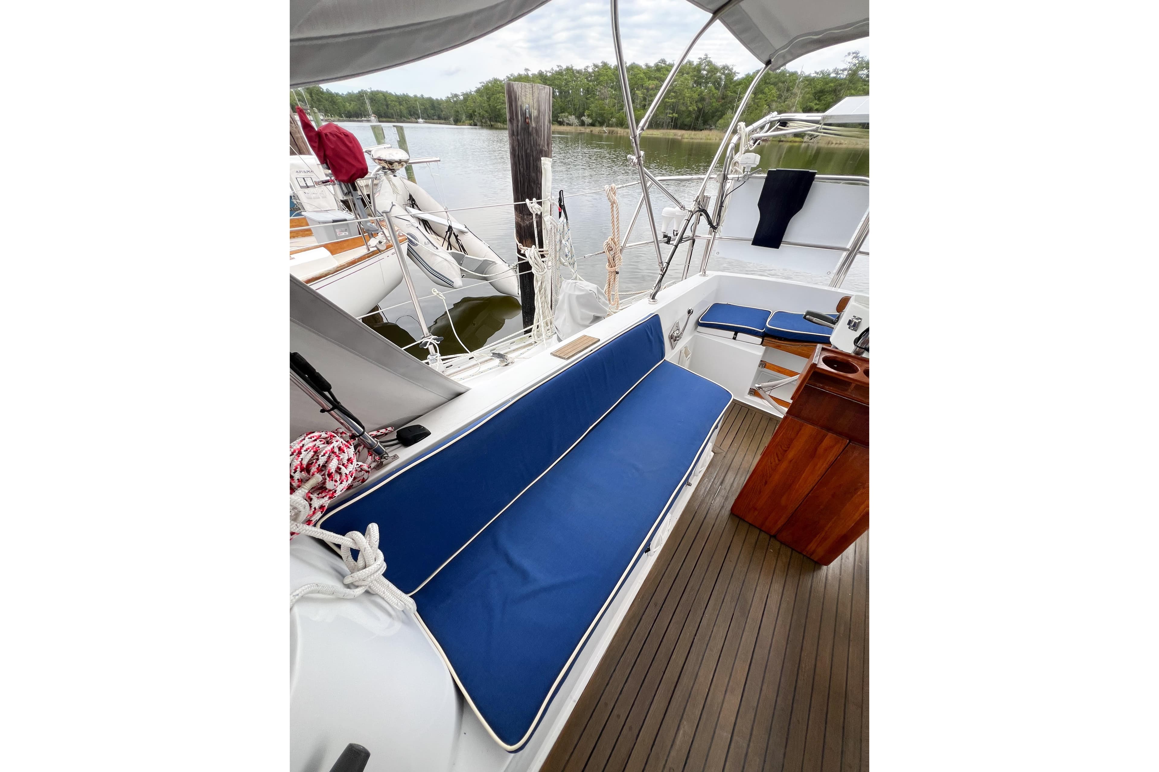 Cockpit of 1984 Trintella 42 sailboat with blue cushions and wooden flooring.
