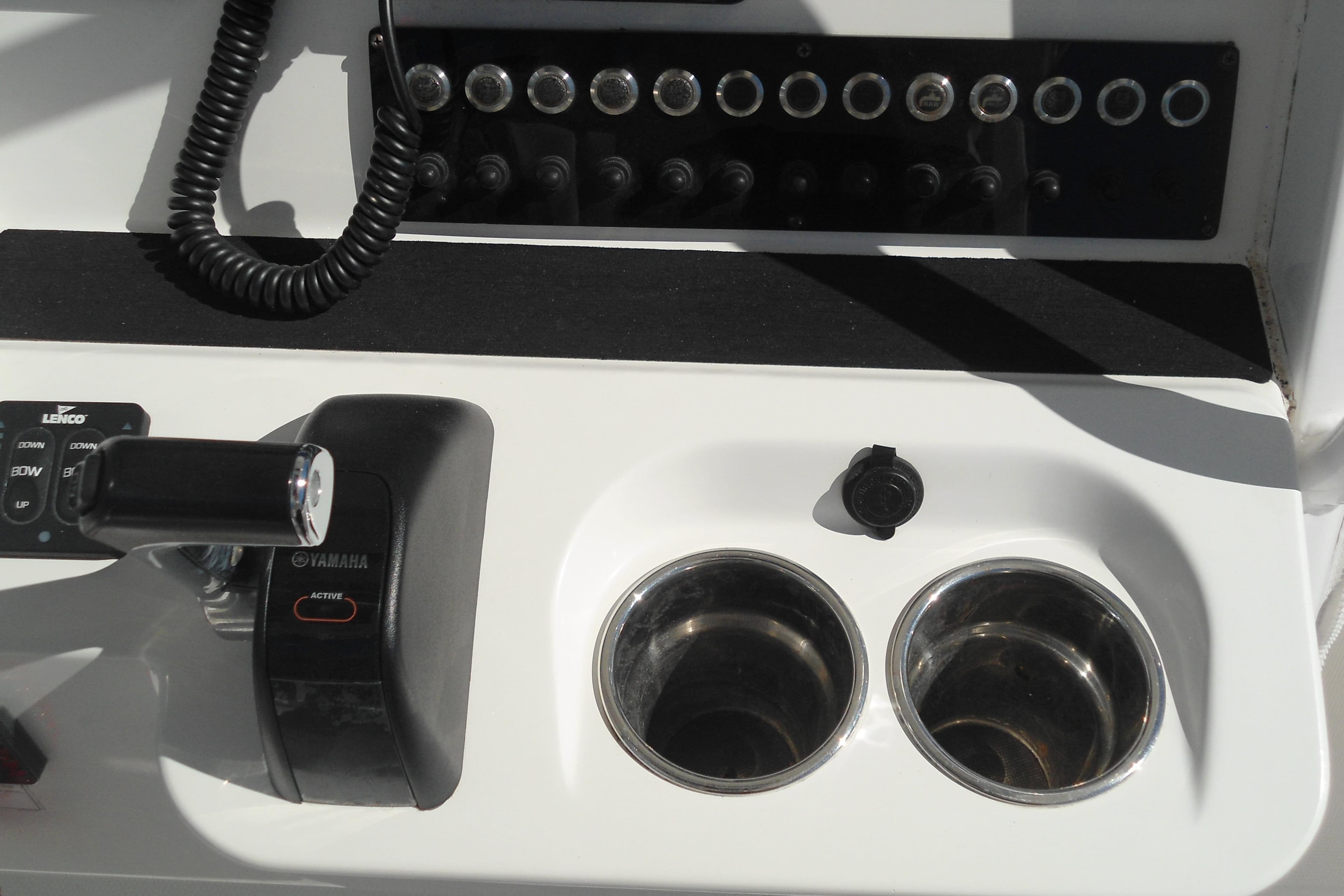 Control panel of a 2019 Edgewater 230CC boat with Yamaha throttle and cup holders.