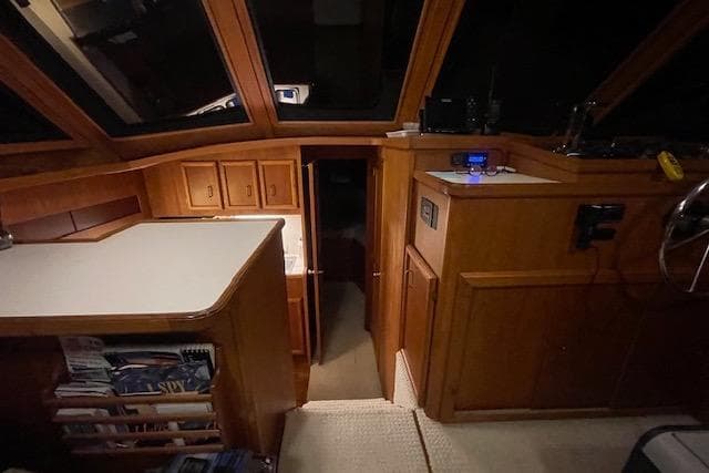 Interior of a 1984 Egg Harbor 33 Convertible boat with wooden cabinetry and helm station.